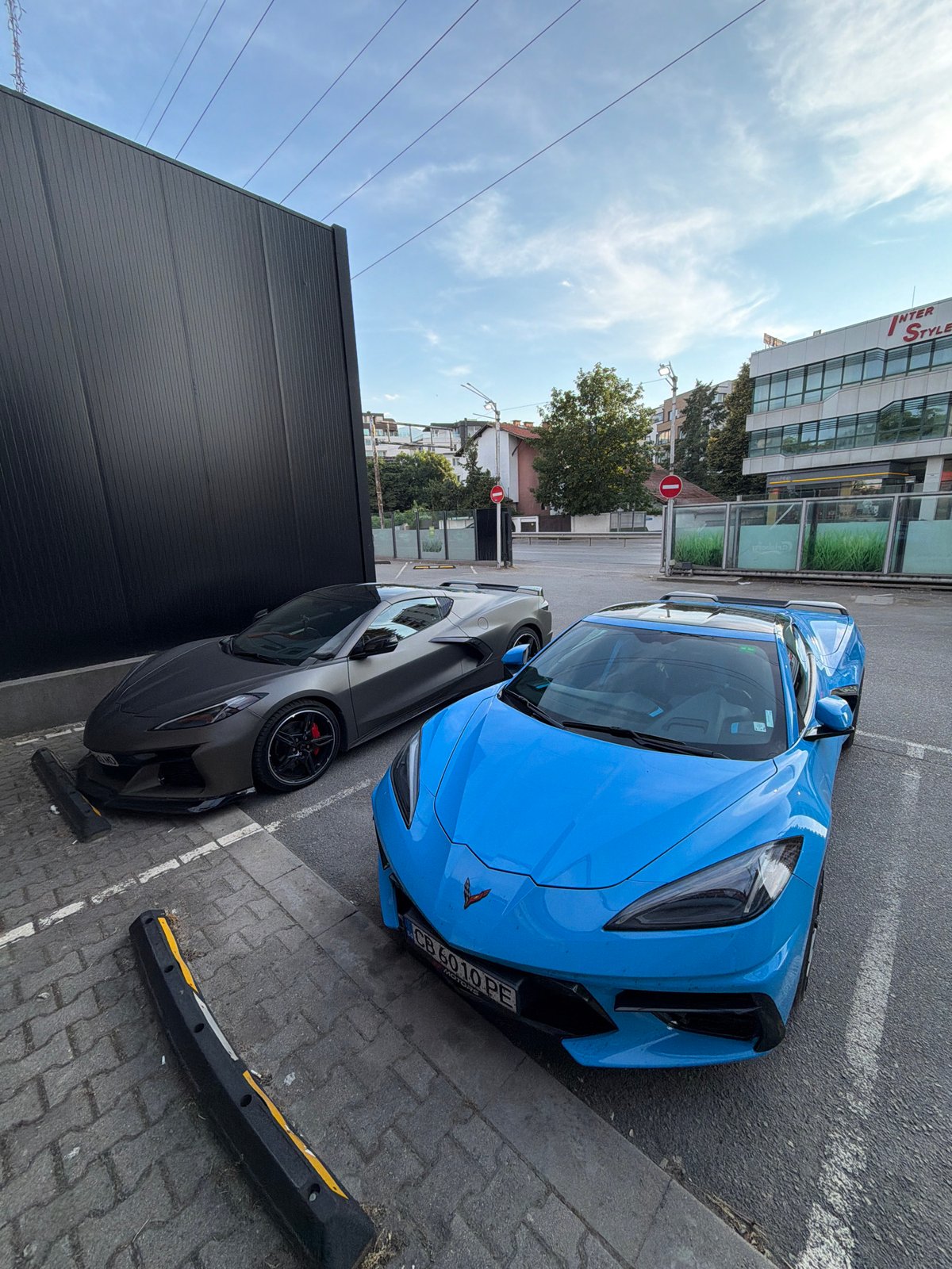 Two Corvettes, dark gray and bright blue, parked together in Sofia.