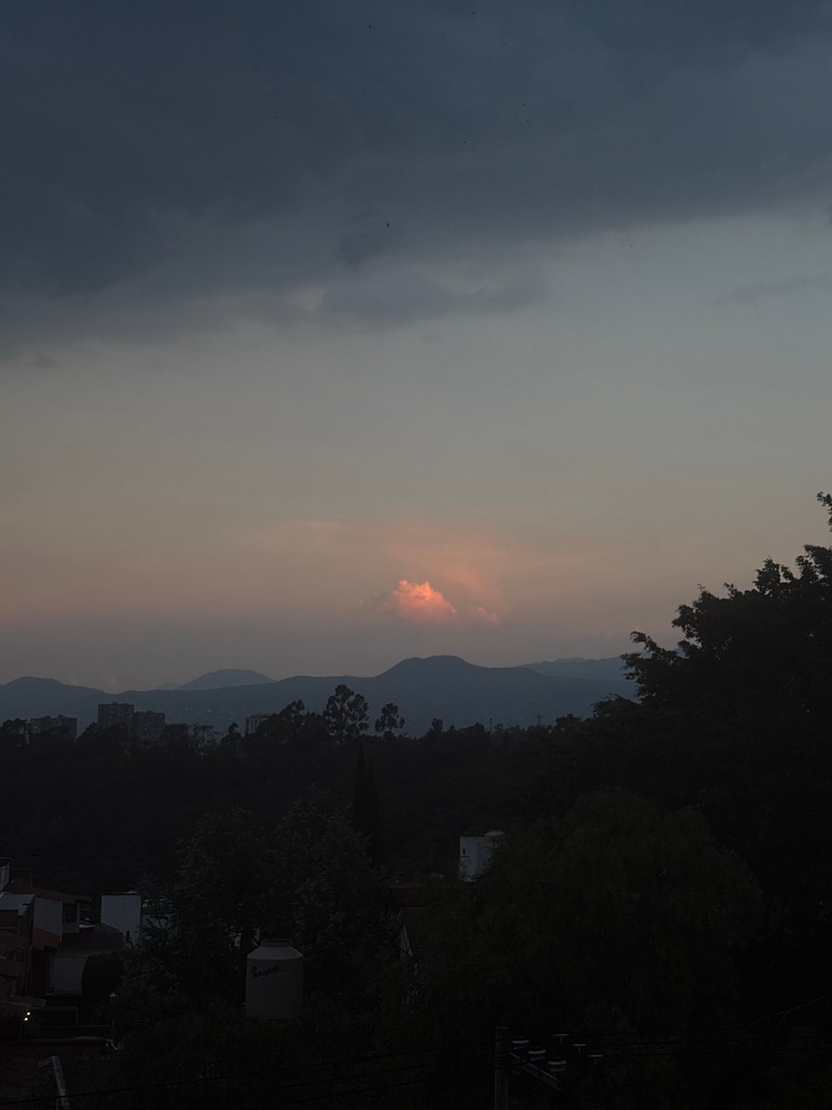 Dusk skyline captured over Mexico City showing distant hills