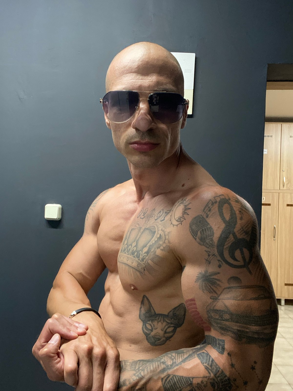 Tattooed man poses in gym locker room in Bulgaria