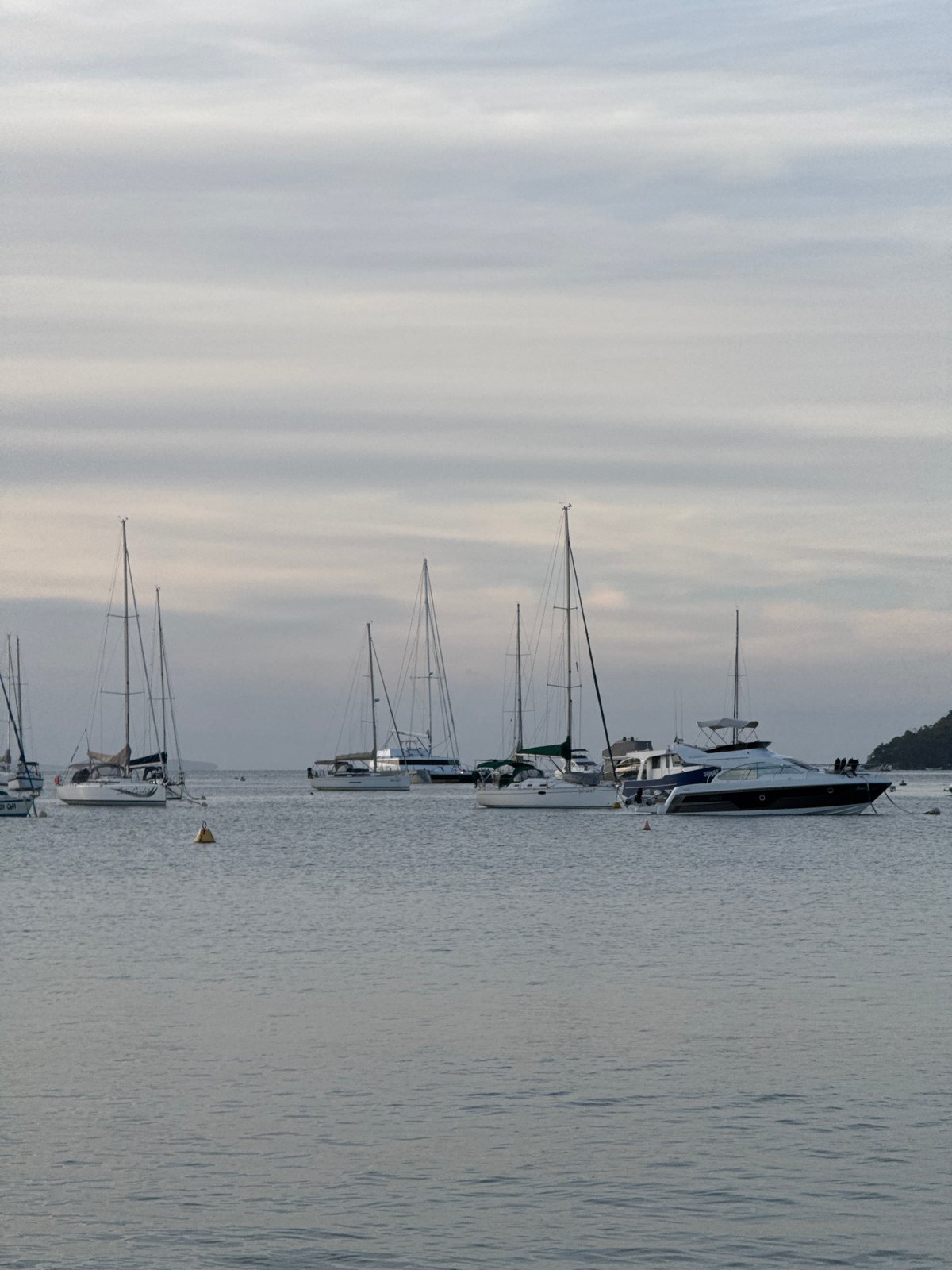 Quiet coastal waterfront at dusk, marina and beachside buildings