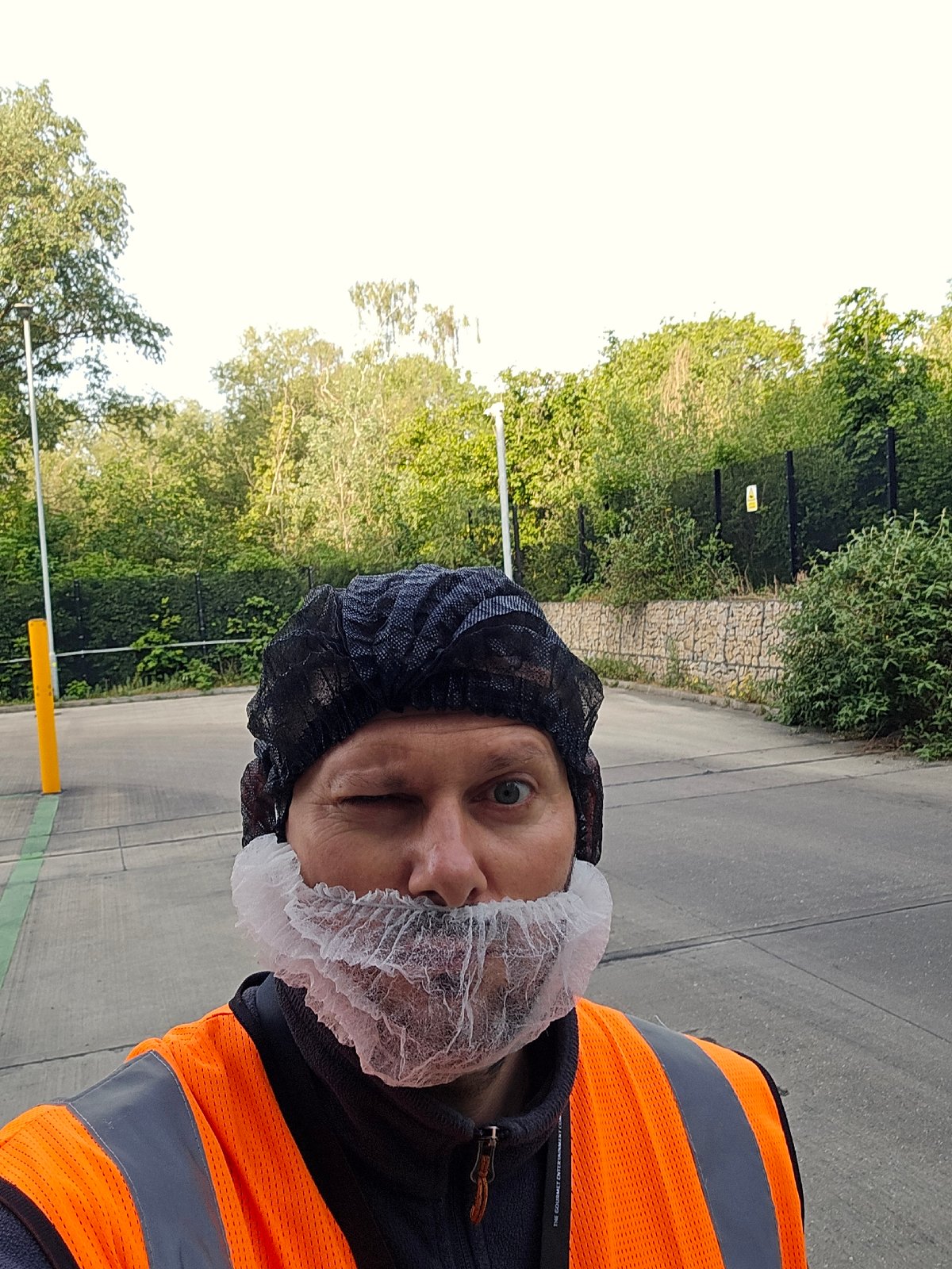 Safety-clad worker spotted winking in London industrial area