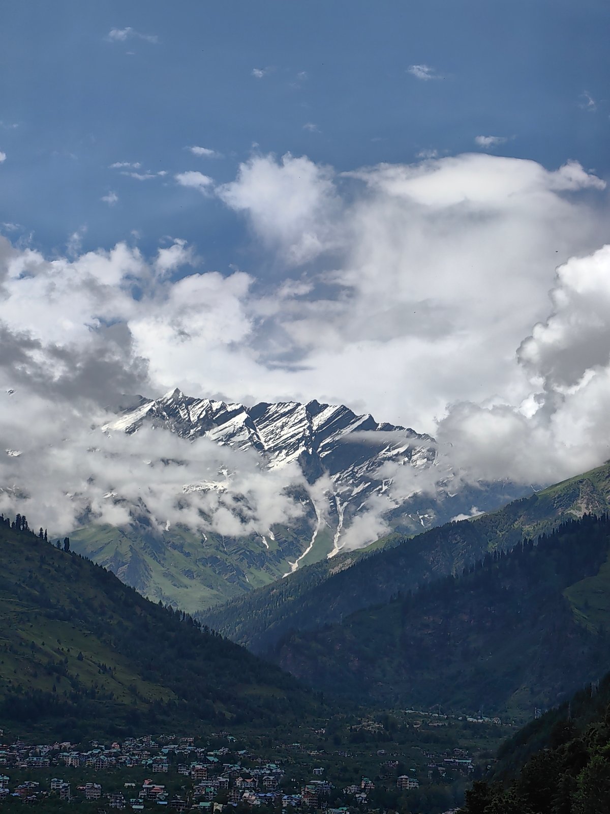 Vashisht valley and Himalayan peaks under a cloudy summer sky
