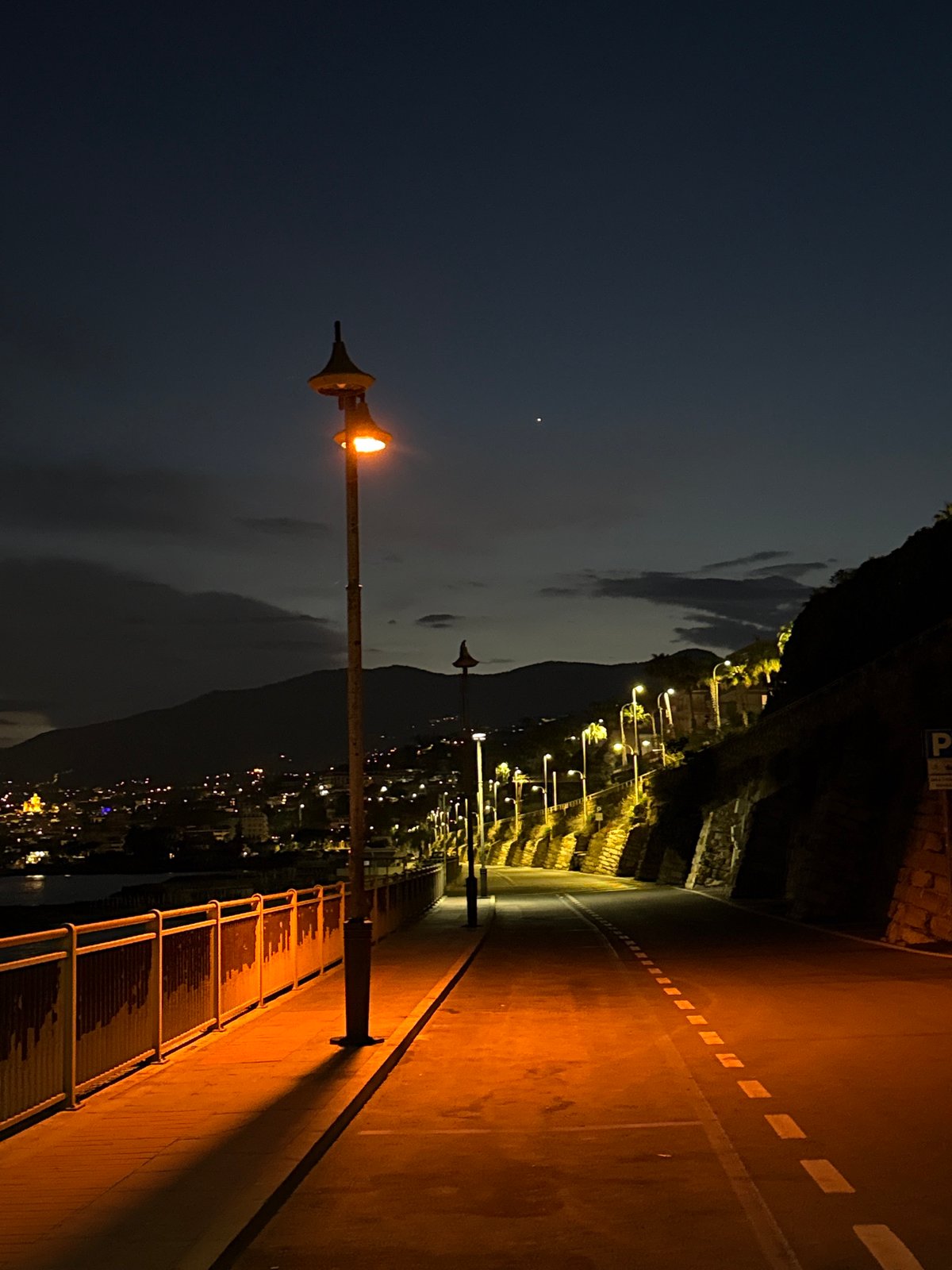 Evening stroll documented along Sanremo's illuminated coastal promenade