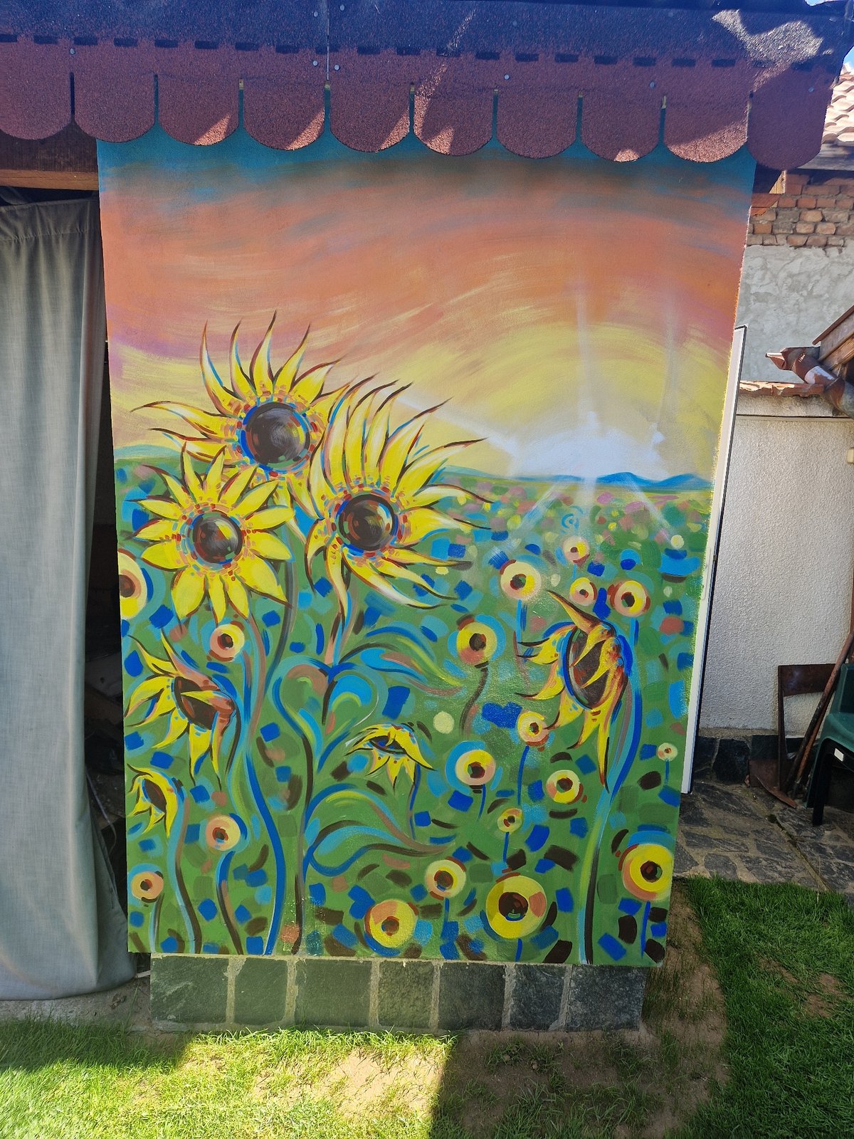 Sunflower oil painting spotted leaning against outdoor structure