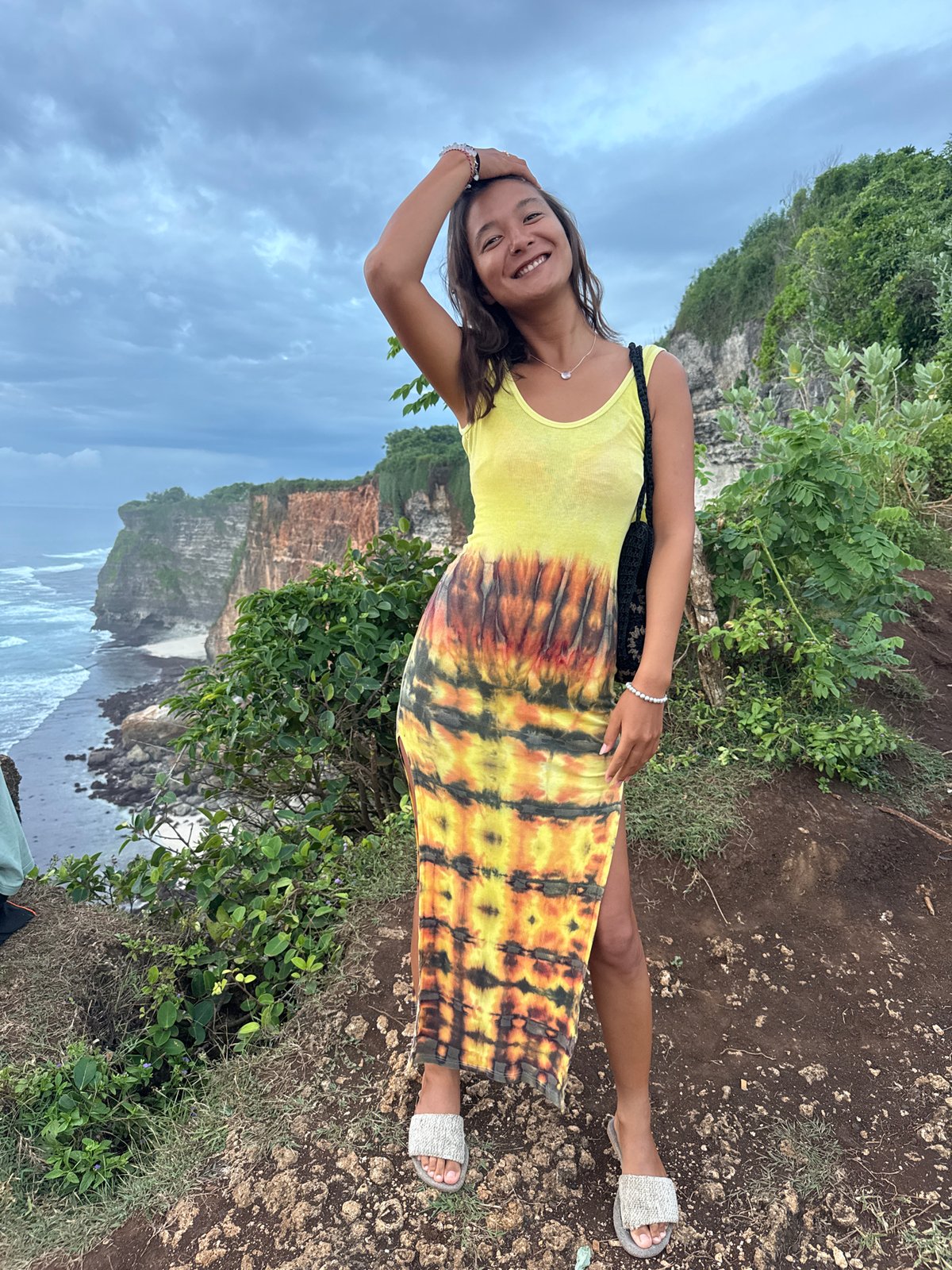 Woman poses and dances on Uluwatu cliffs in Bali