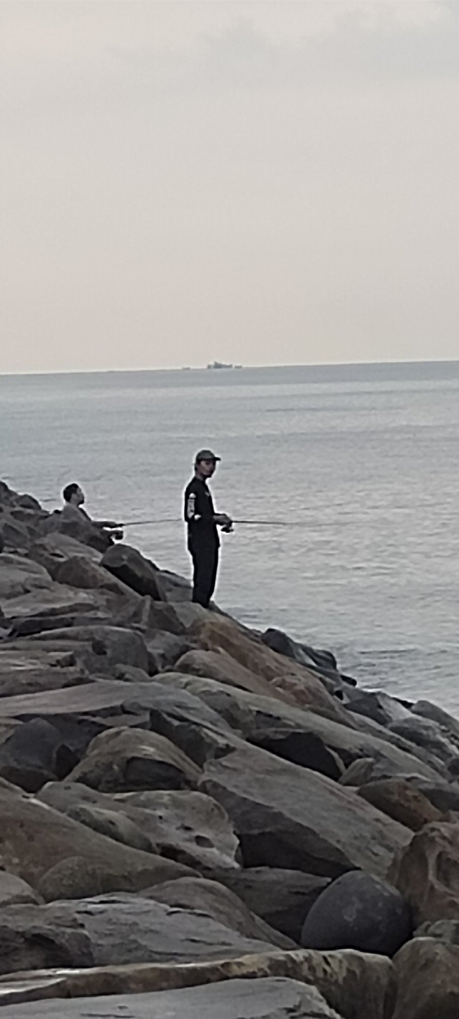 Fishing and coastal life along Lhokseumawe's rocky shoreline