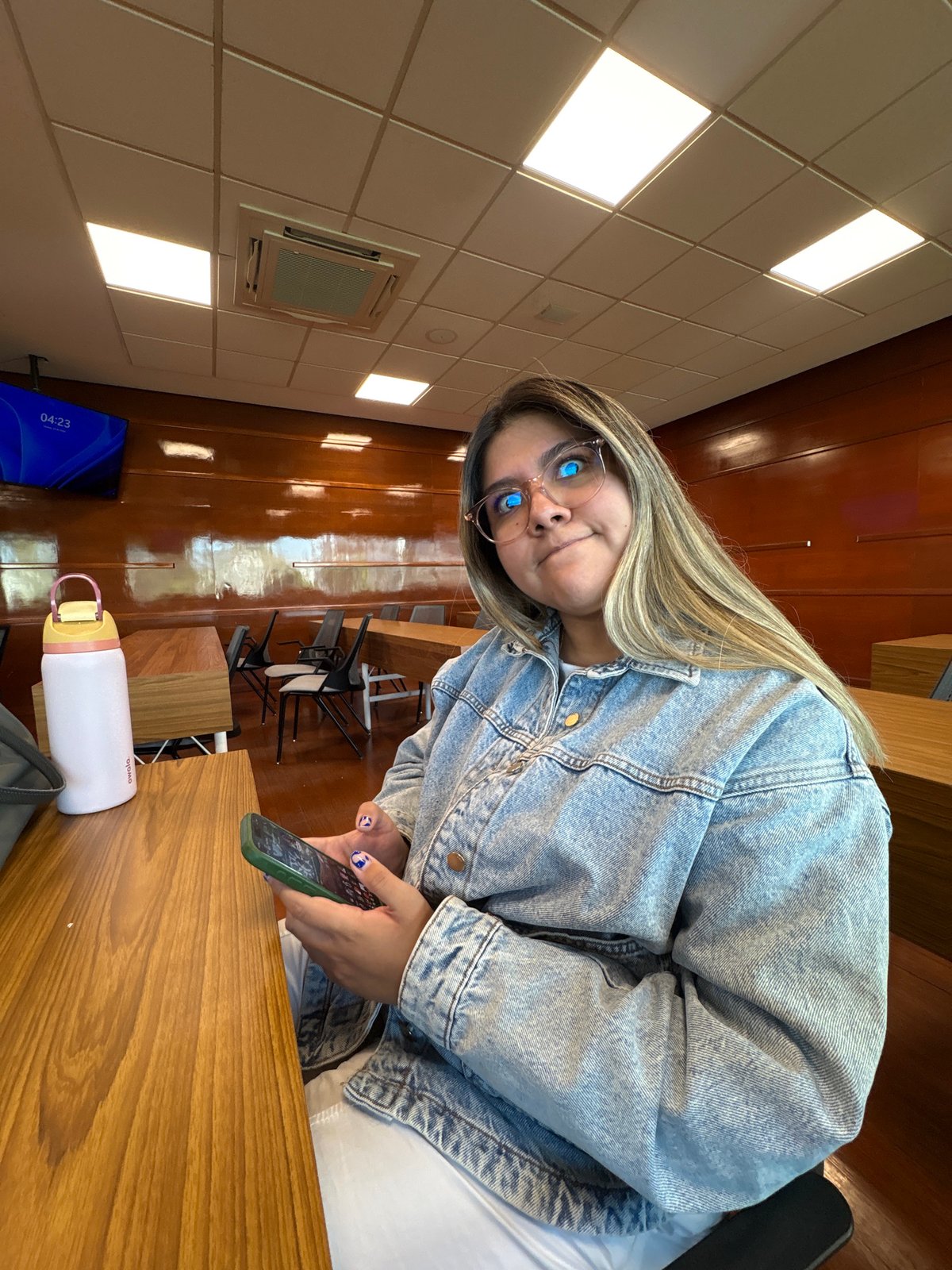 Woman uses phone in public indoor space in Puebla