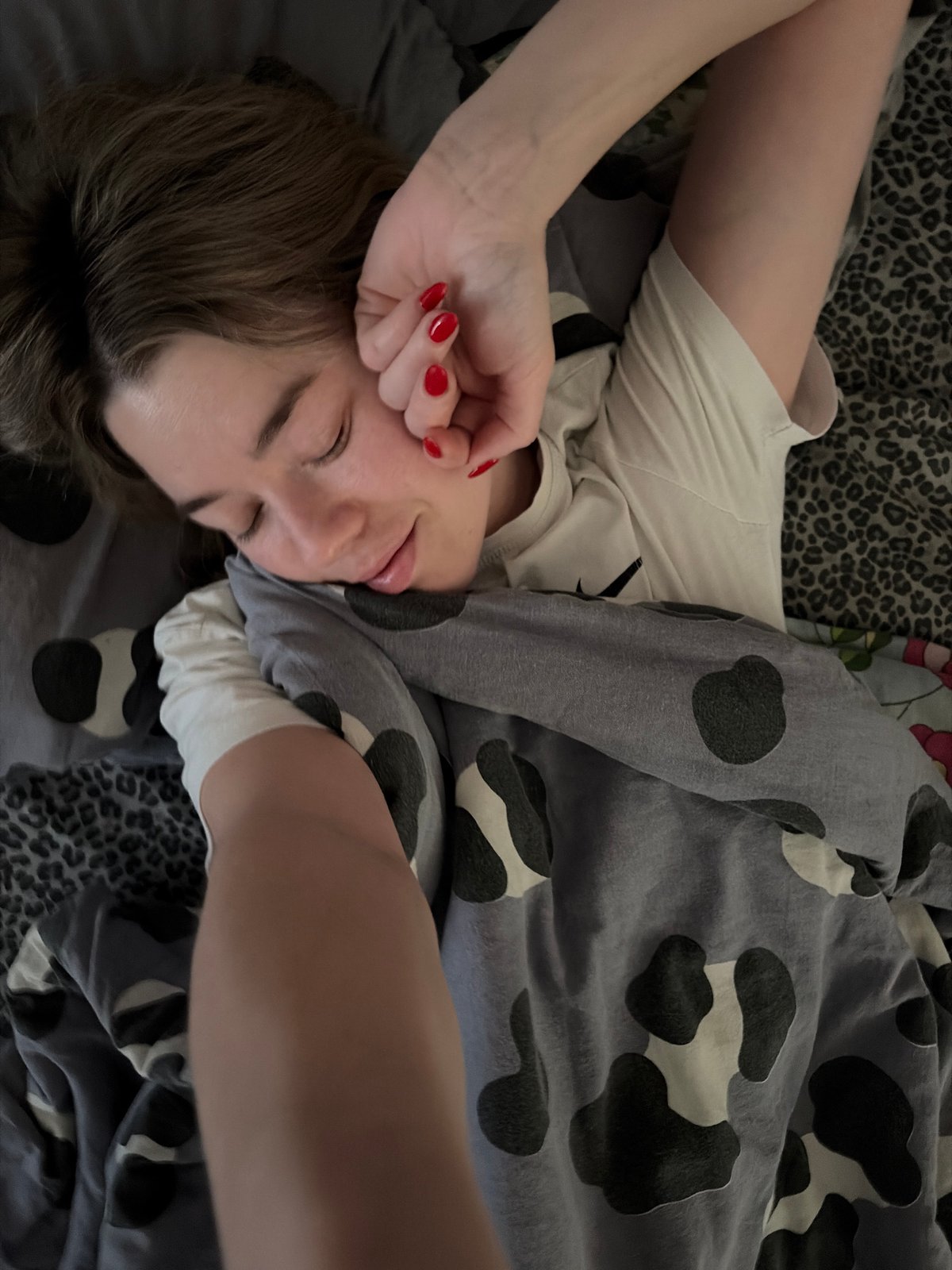 Woman rests in bed during early morning hours in Chaikovsky