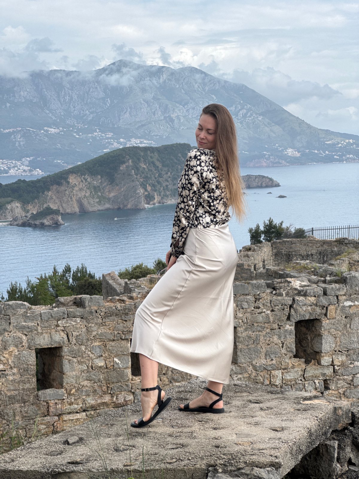 Tourist visits stone ruins as ants forage in Budva