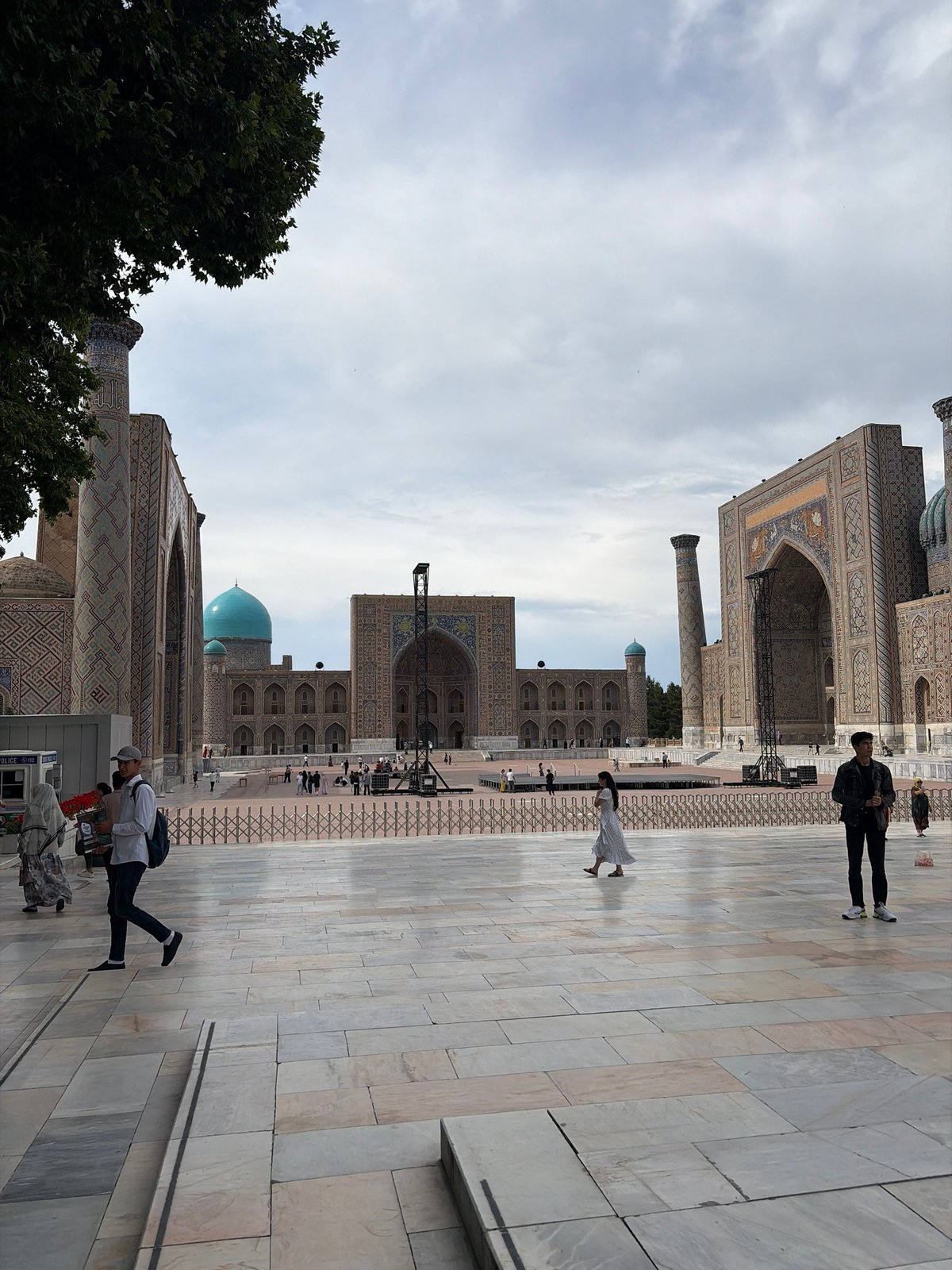 Tourist documents Samarkand's Registan Square architectural complex under overcast skies