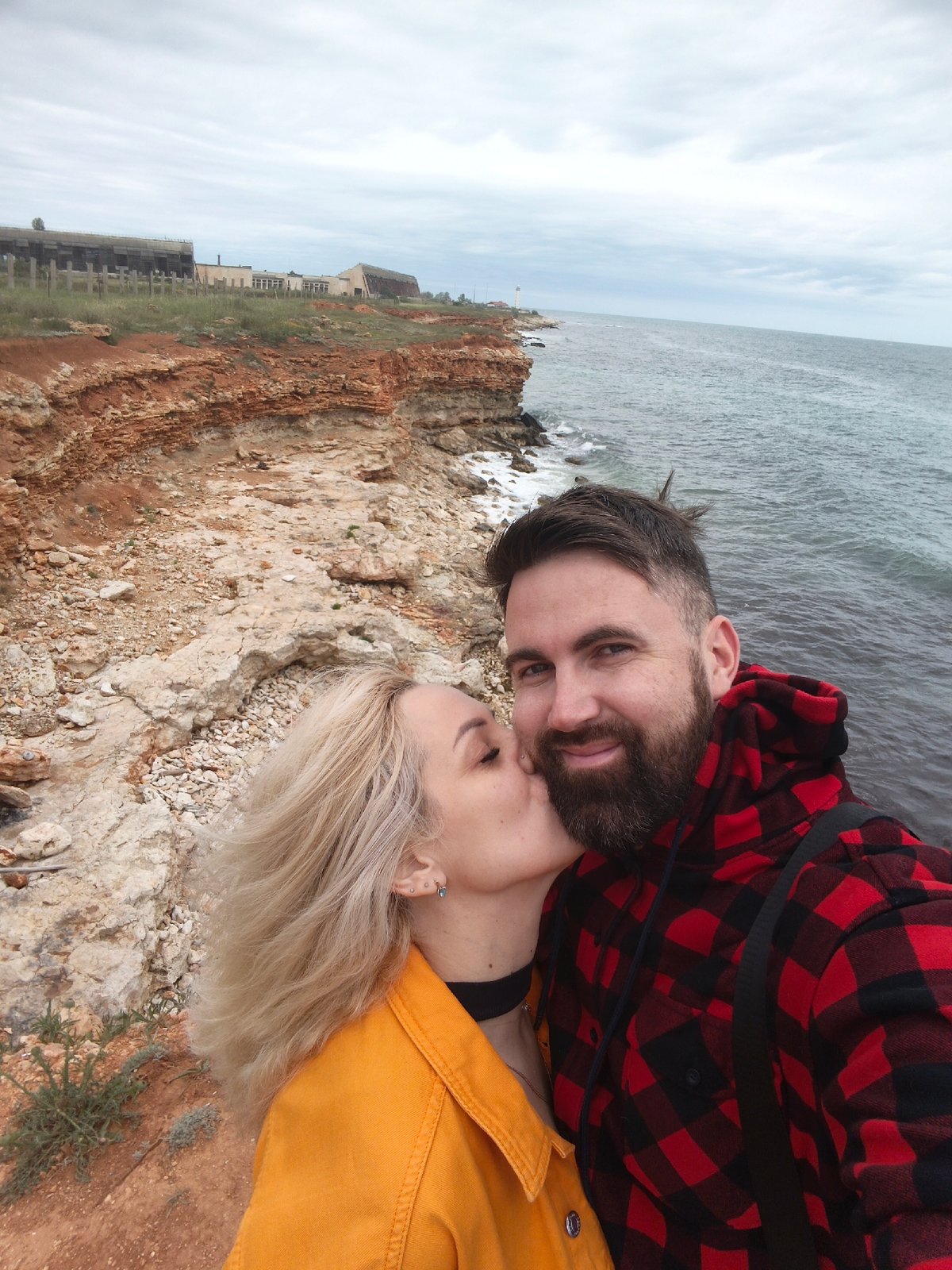 Couple shares tender moment at Sevastopol coastline amid spring flowers