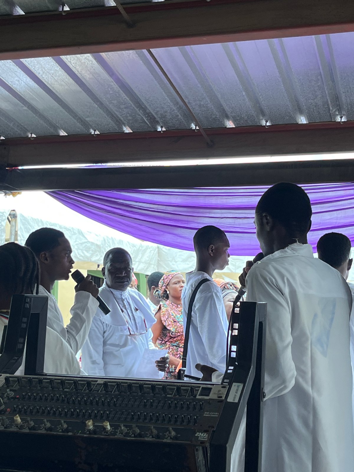 Outdoor religious gathering with live music and white-robed attendees