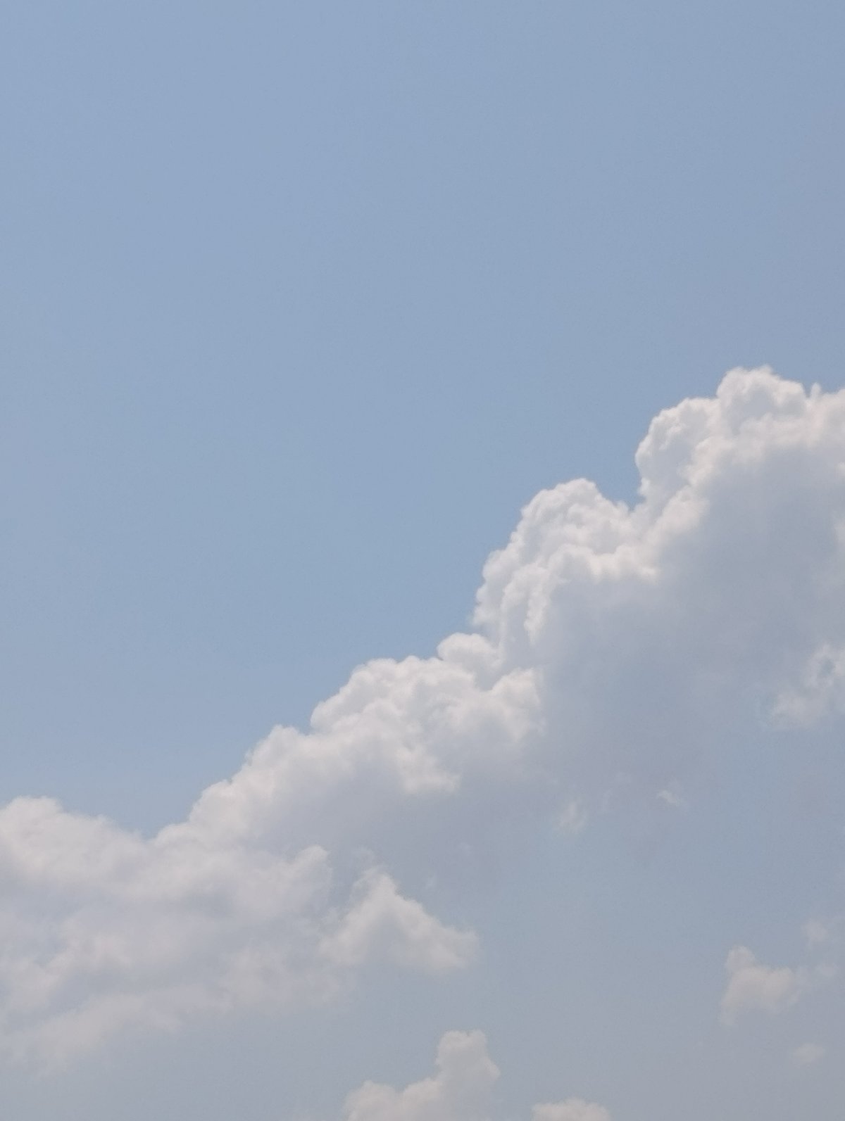 Cumulus cloud drifts across a pale blue sky over Varna