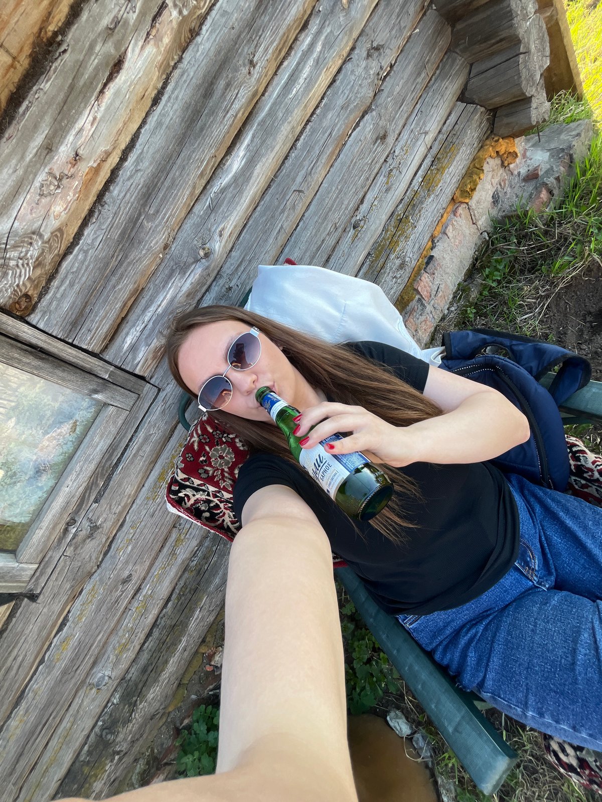 Woman relaxes with drink on wooden platform in Chaikovsky