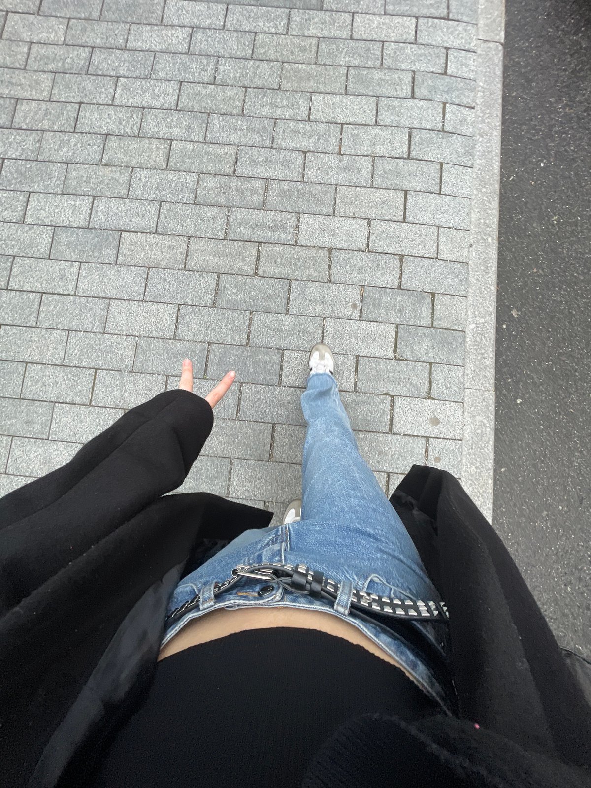 Person in jeans photographed on brick pavement in Moscow