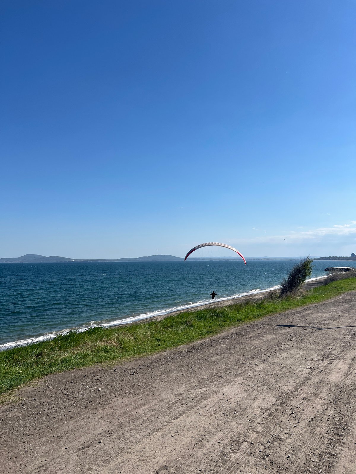 Paraglider spotted over Burgas coastline on sunny afternoon