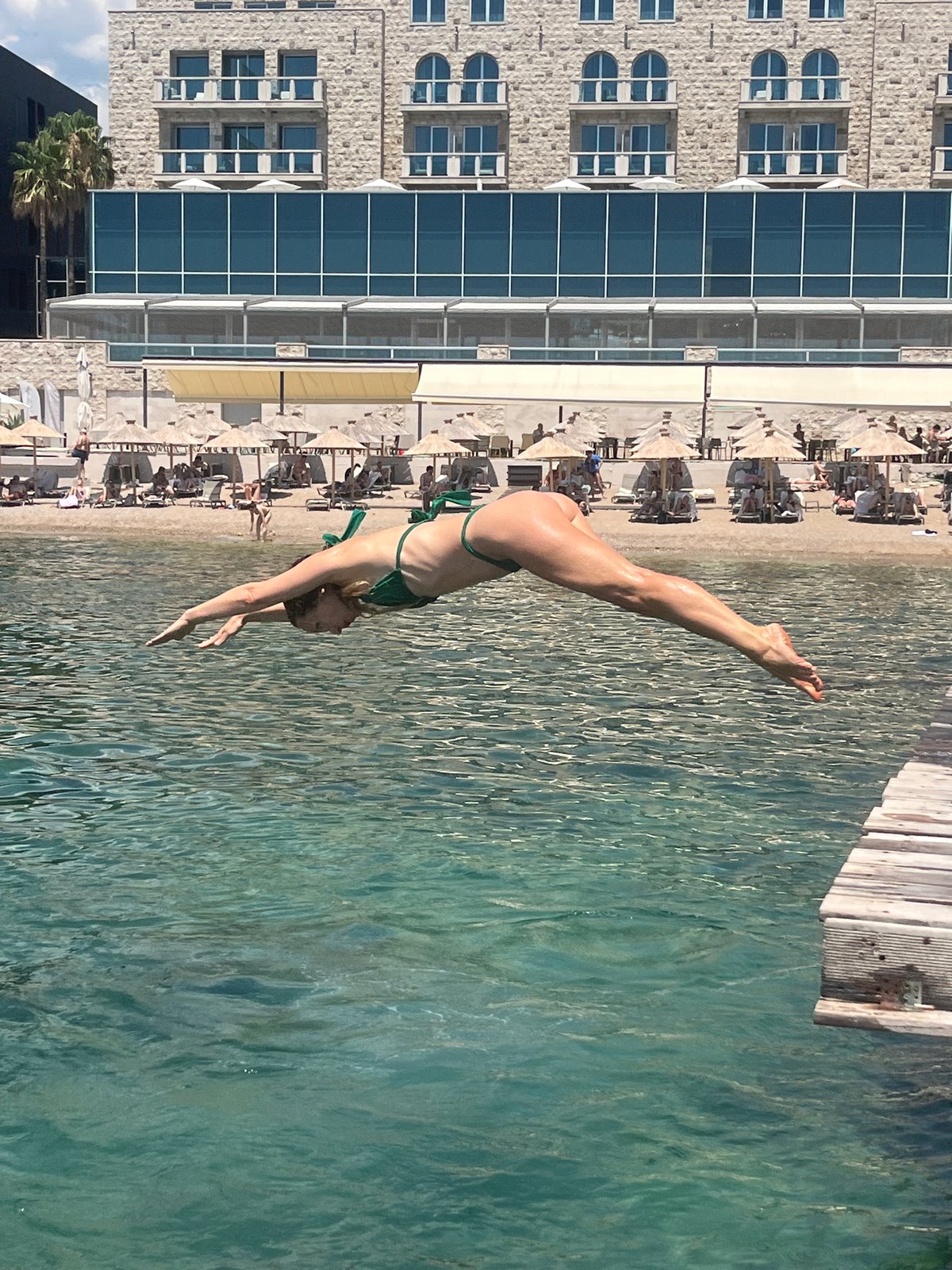 Diving into turquoise Adriatic water off Budva's concrete ledges