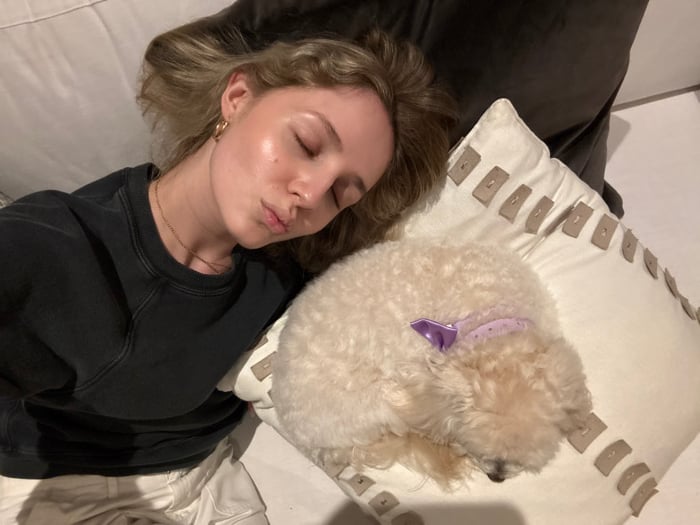 Girl and small dog rest together indoors in Coral Gables