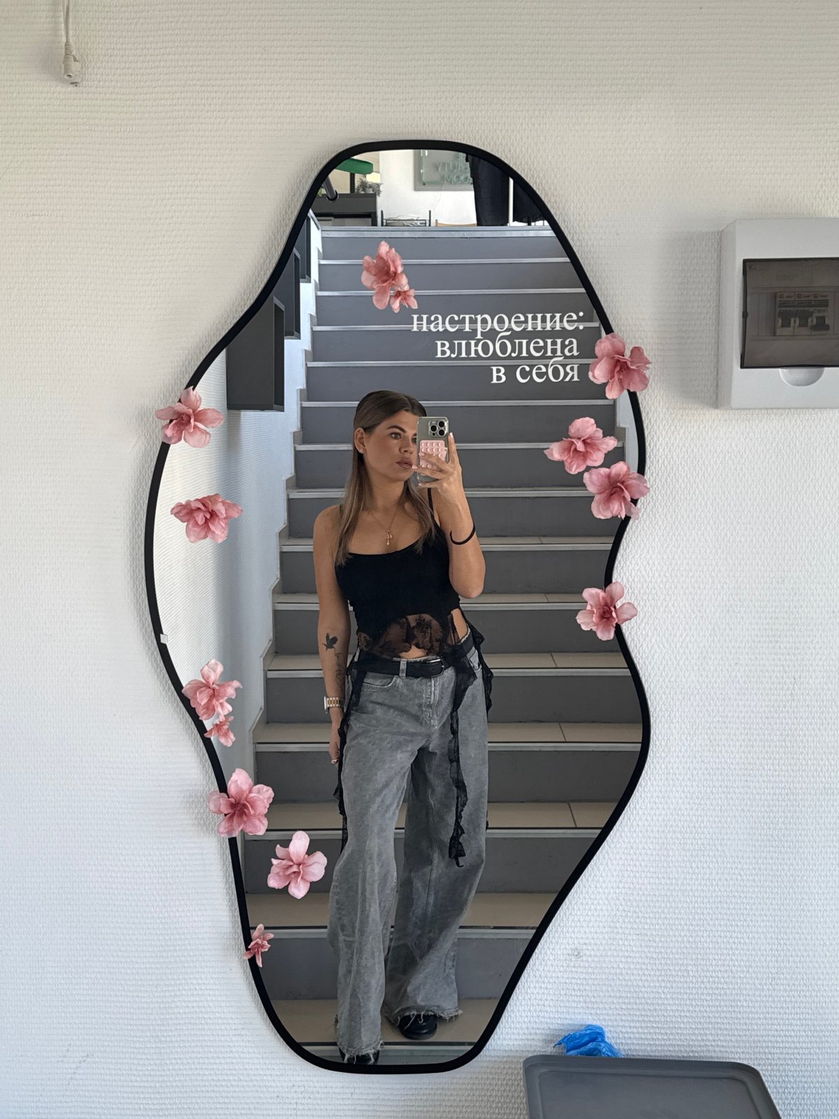 Woman takes mirror selfie in decorated stairwell in Chaikovsky