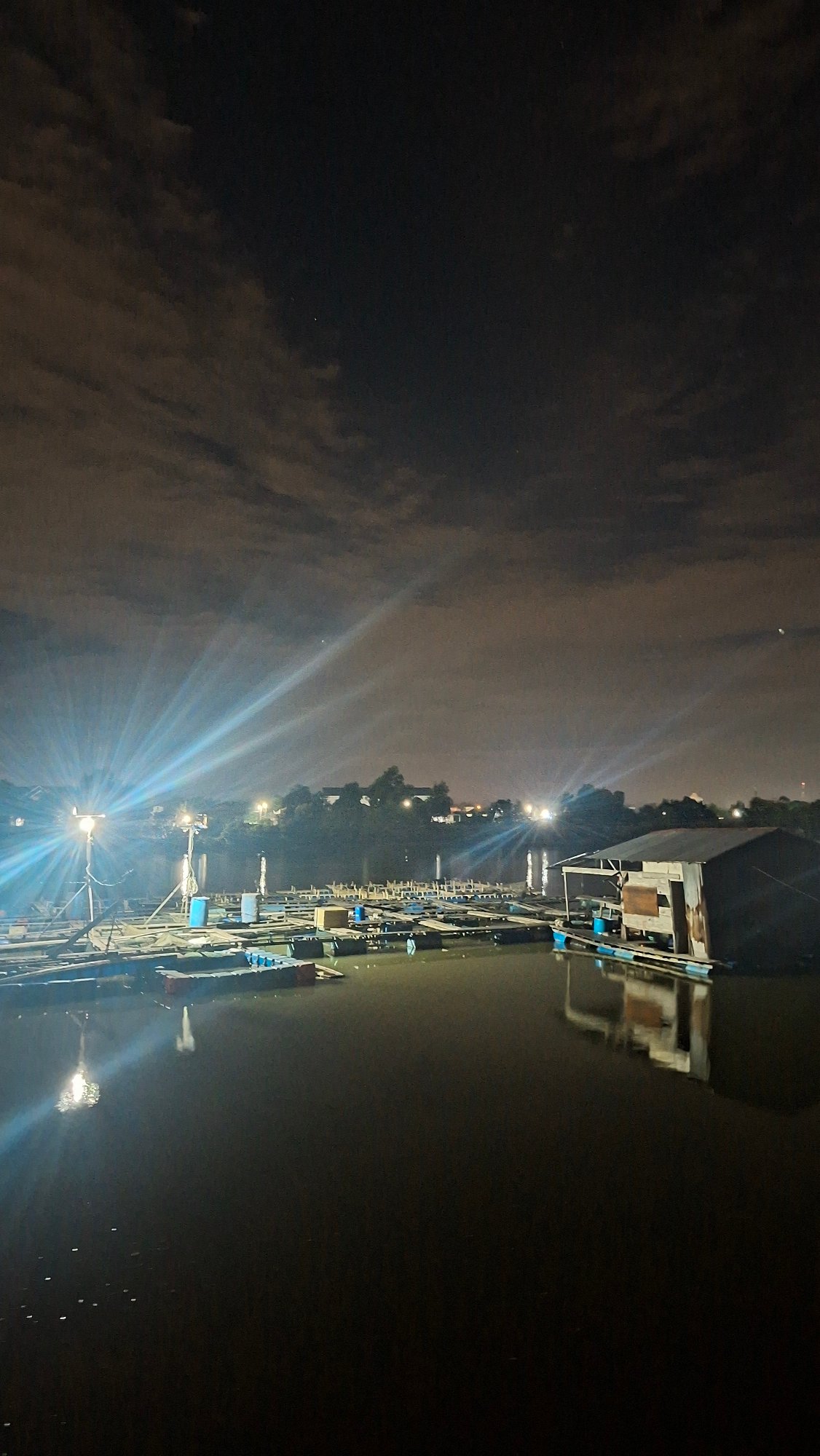 Night fishing from a wooden pier in Lhokseumawe, Indonesia