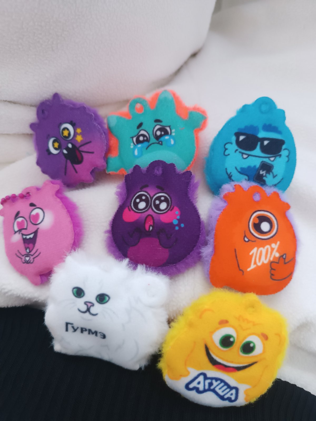 Person displays collection of colorful plush monster keychains