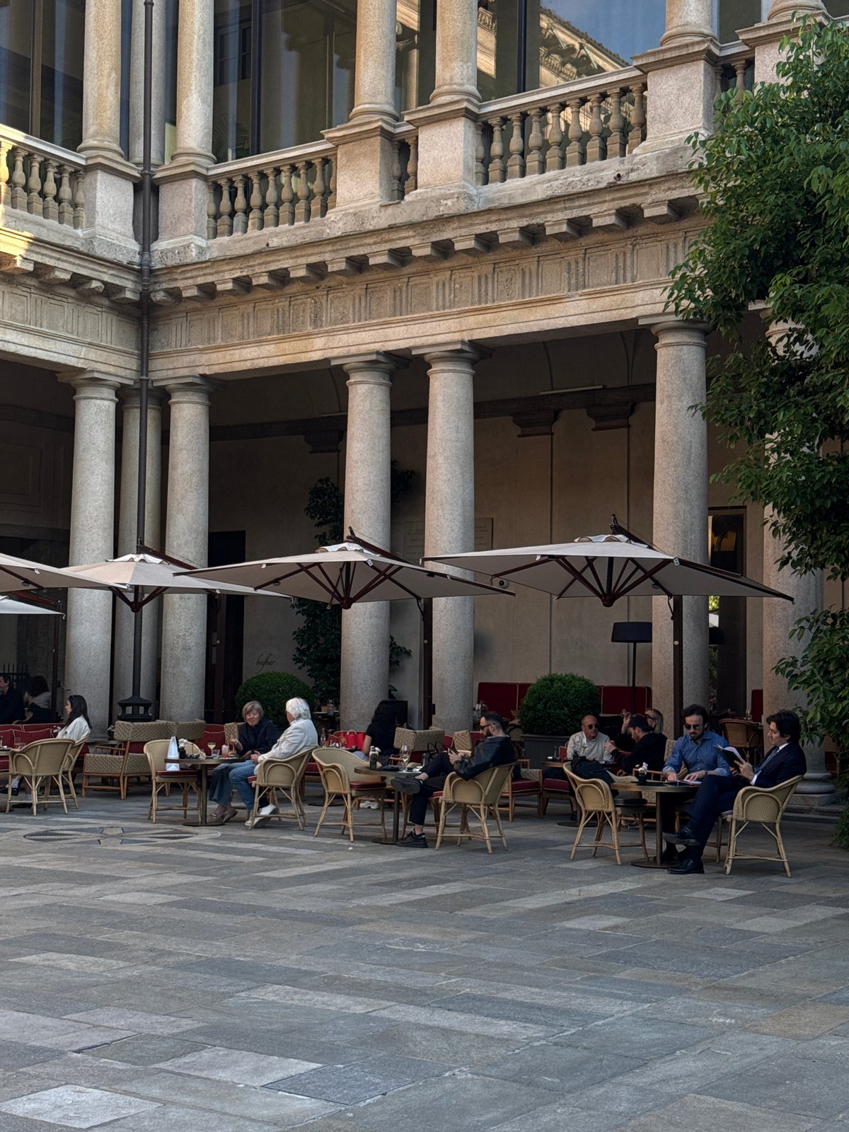 Afternoon dining scene captured at Milan's classical courtyard venue
