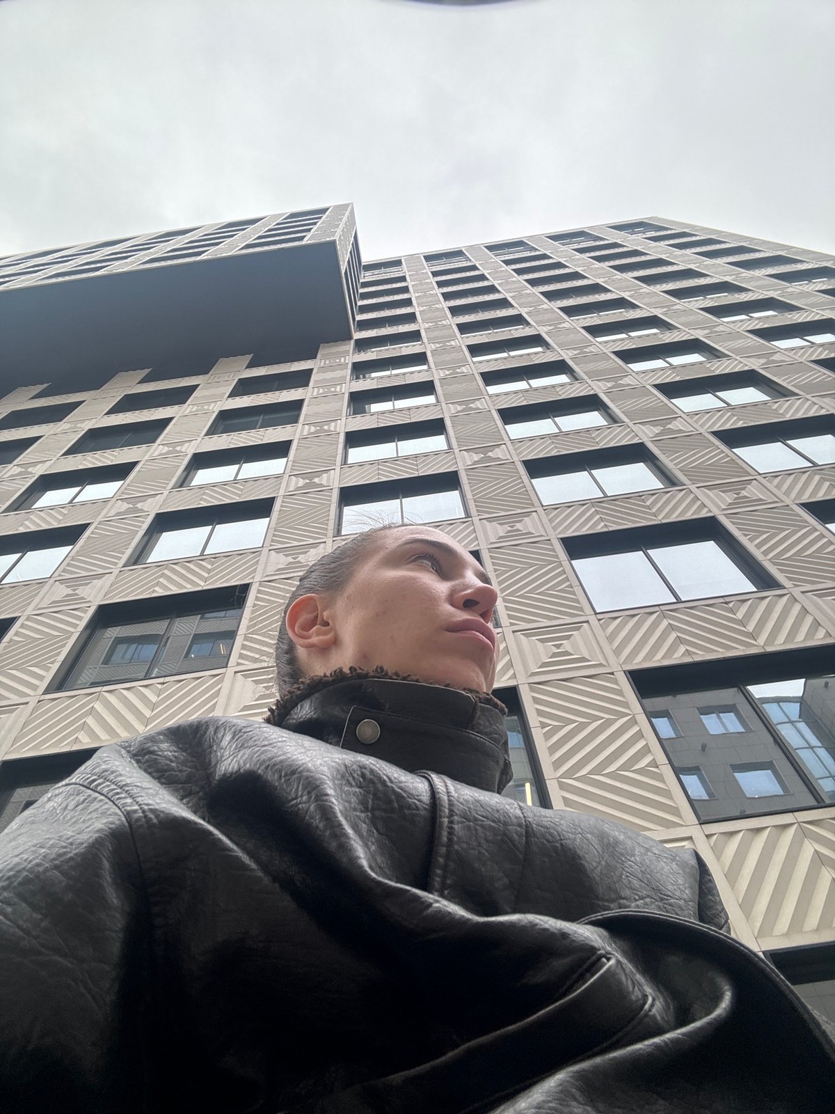 Person gazes up at modern building in Moscow