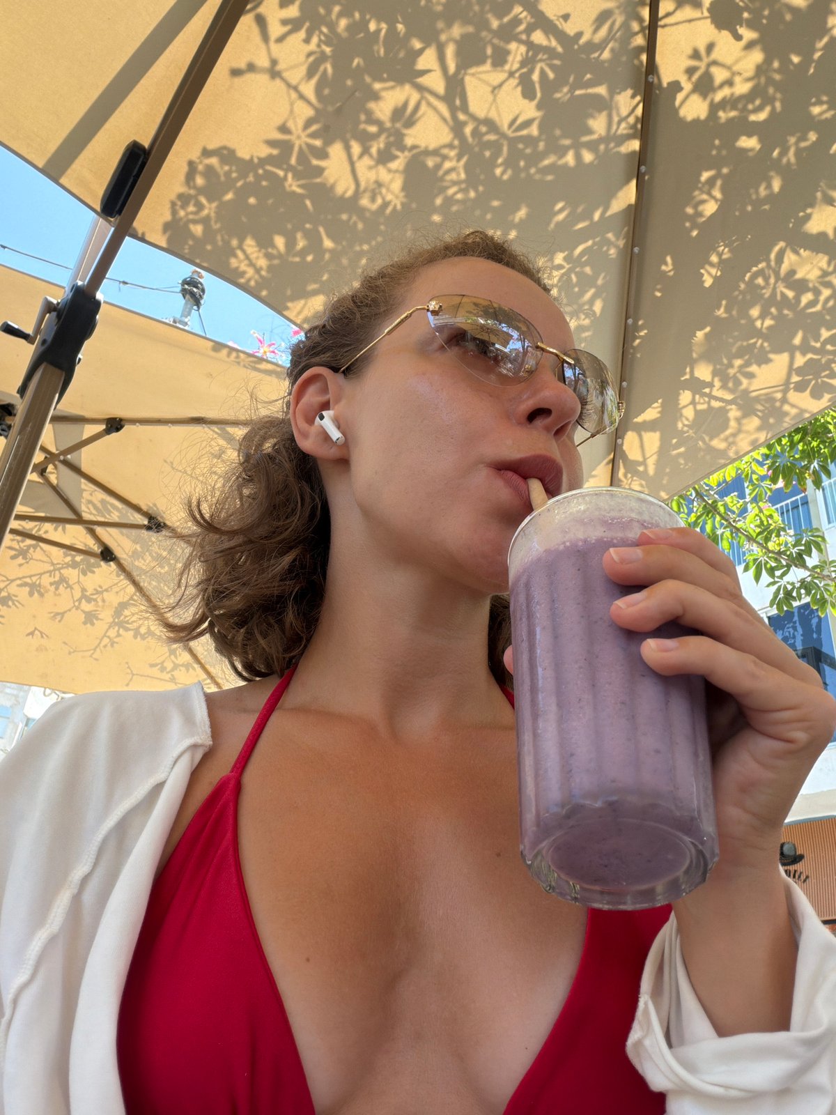 Purple smoothie and earbuds on a Tel Aviv summer morning
