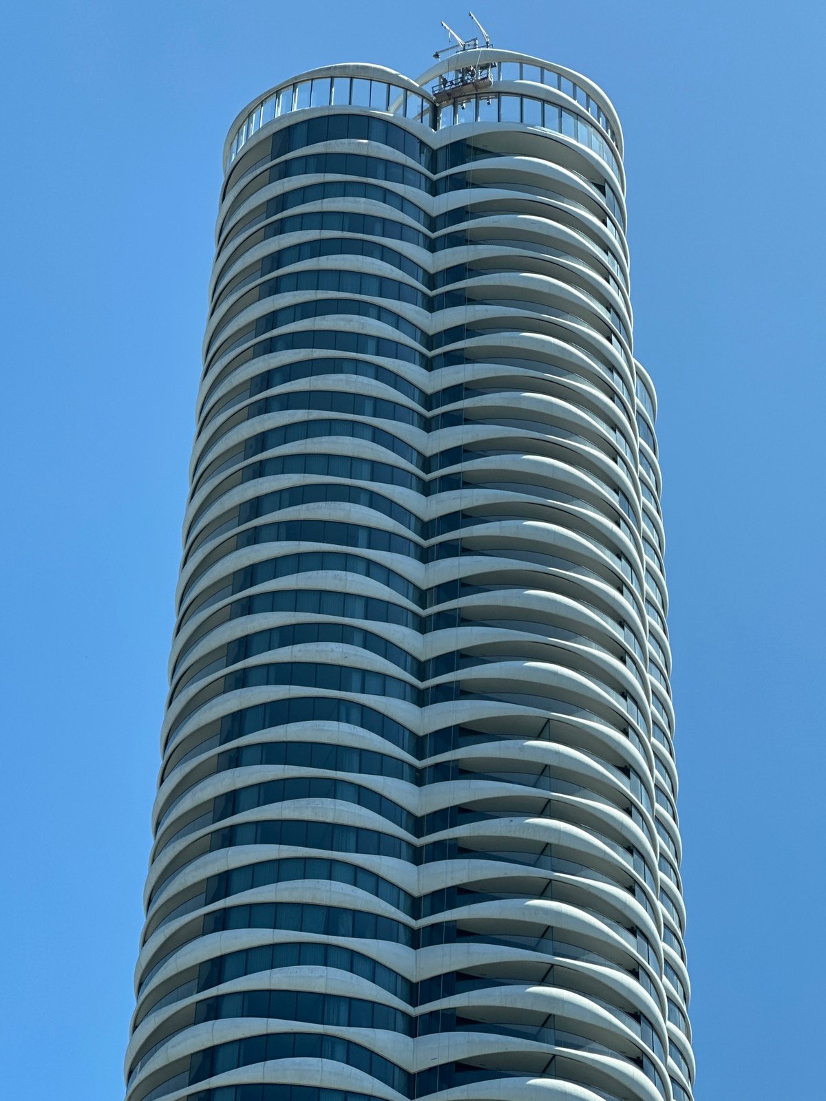 Wavy glass skyscraper stands out against Vancouver's blue sky