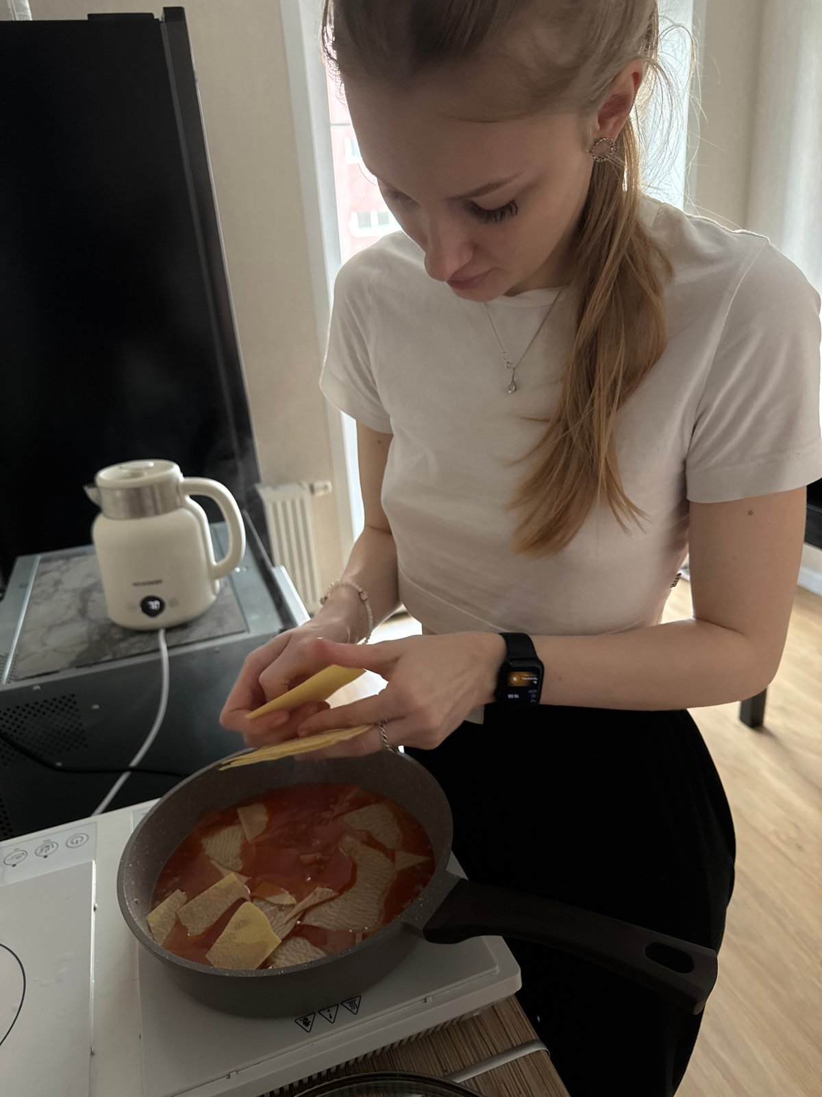 Woman prepares lasagna in Perm kitchen