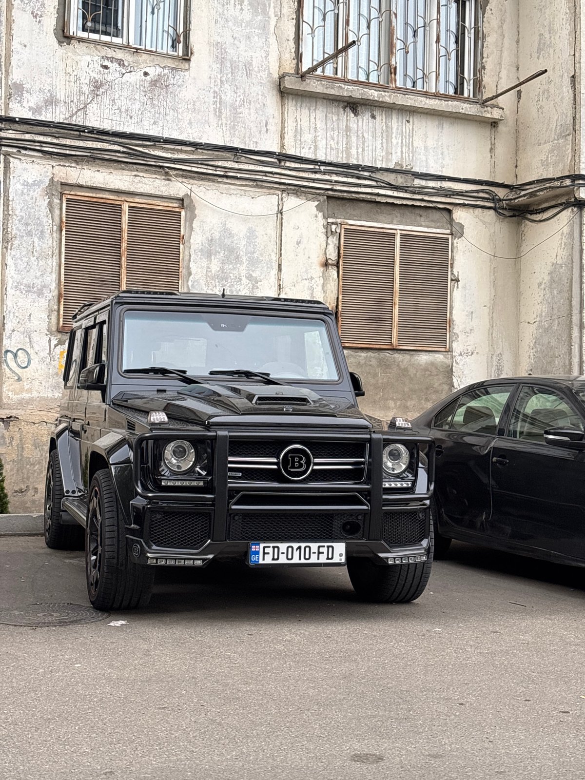Street scenes documented in Tbilisi featuring luxury SUV, murals