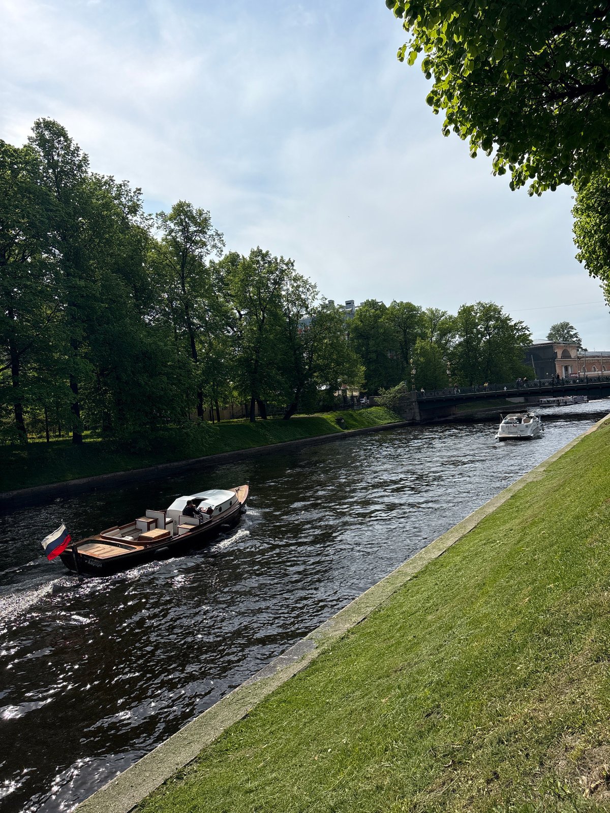 Tourist boats and pedestrians active in Saint Petersburg canals