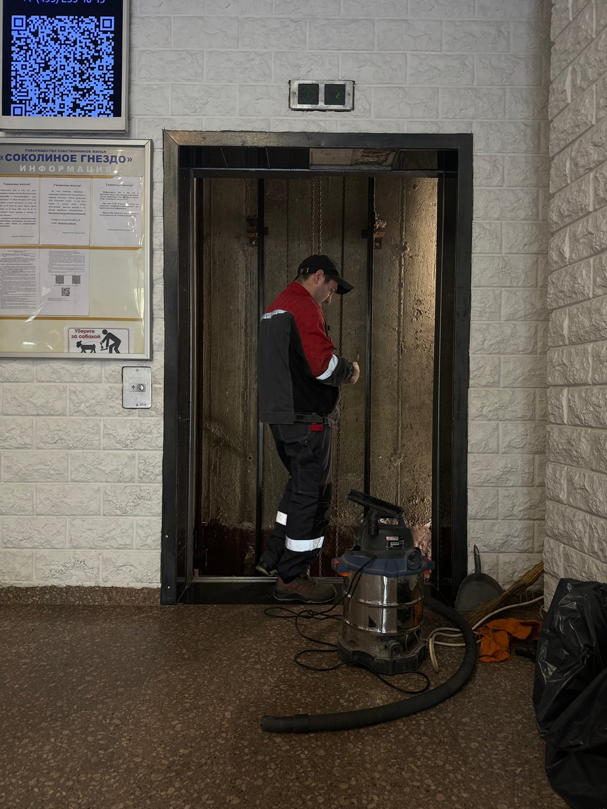 Maintenance worker performs repairs in open elevator shaft