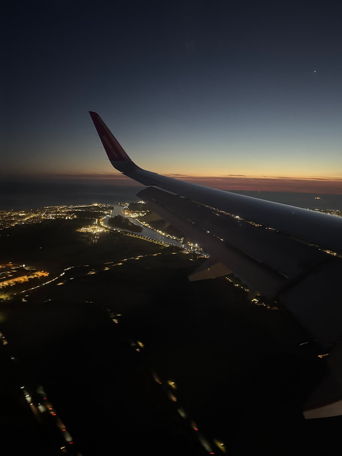Wizz Air passenger documents evening flight over illuminated Rome