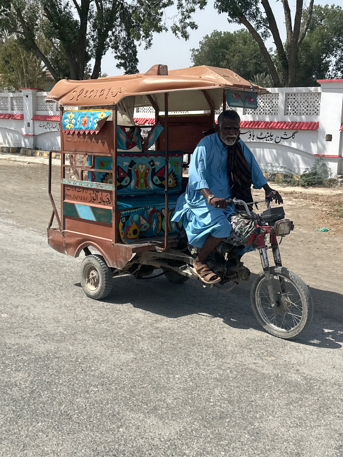 Morning traffic includes rickshaws, motorcycles, cargo trikes on paved roads