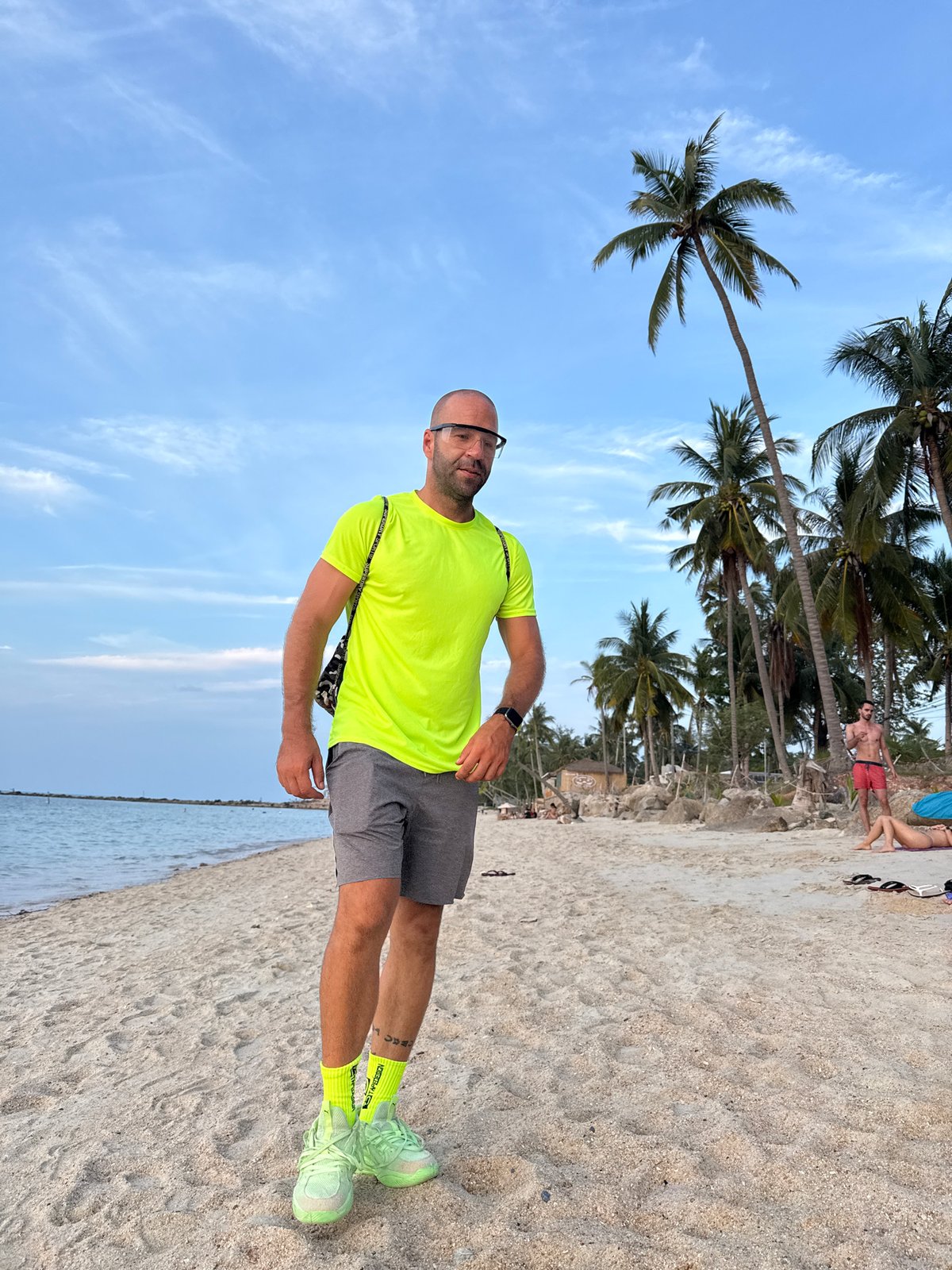 Sunset hour on a Ko Samui beach, neon gear and a stray dog