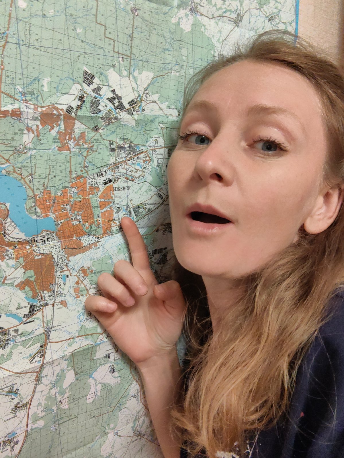 Woman points at Izhevsk city map in Russia