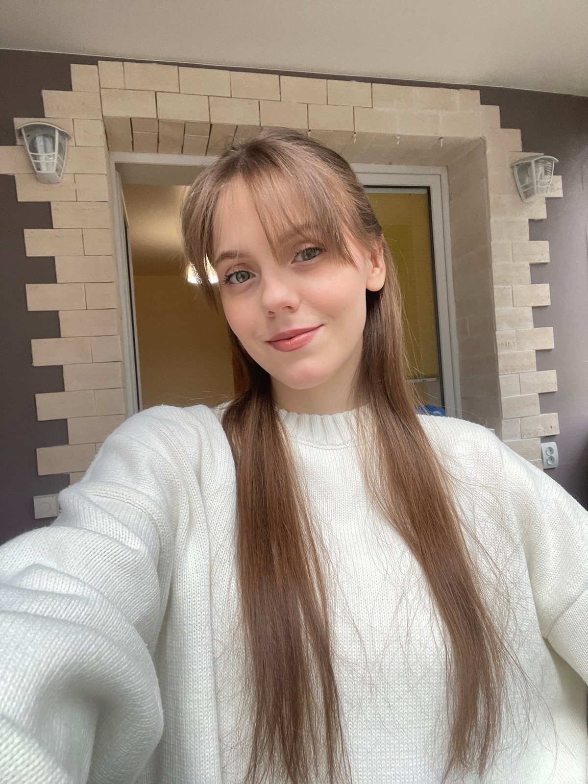 Woman takes morning selfies by window in Ufa