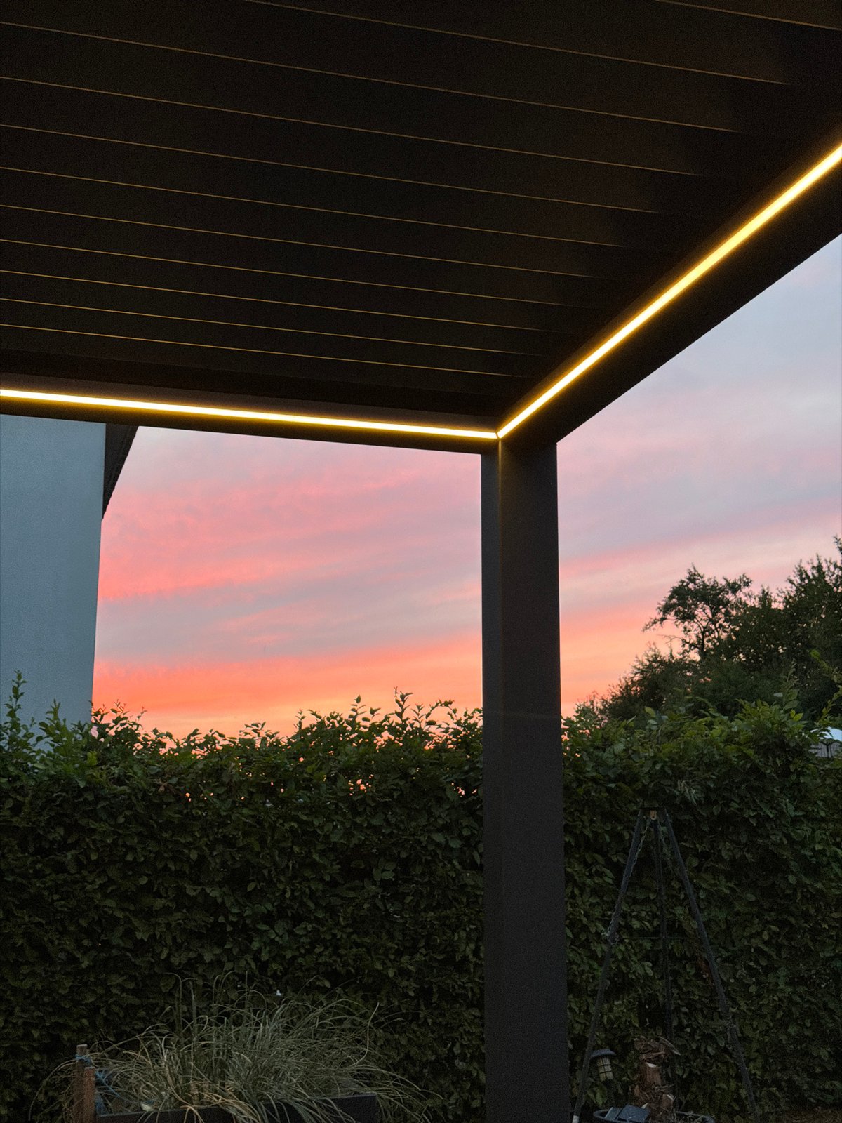 Backyard dinner under a pergola as dusk settles in Junglinster