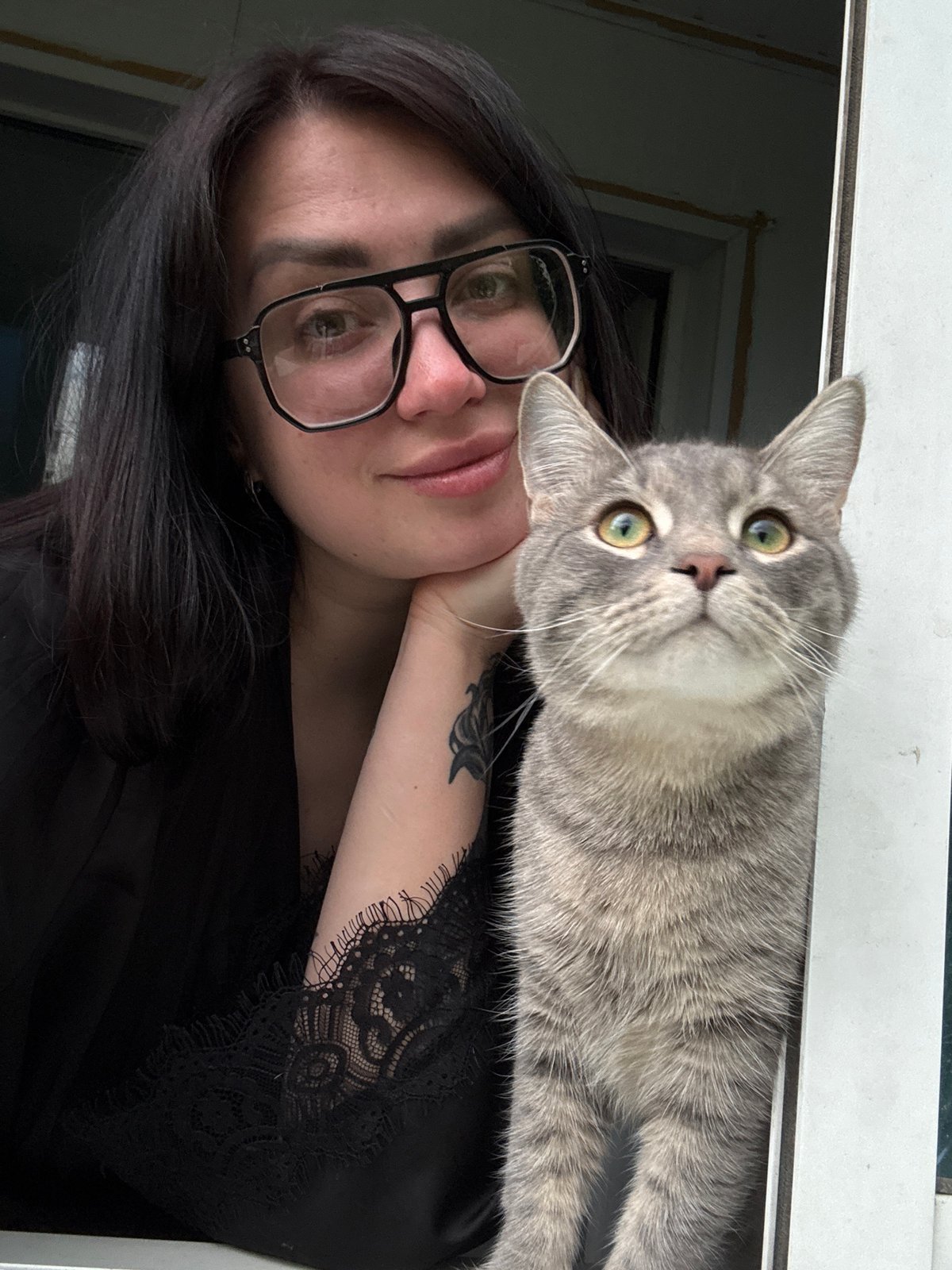 Woman takes selfies with cats and husky near window