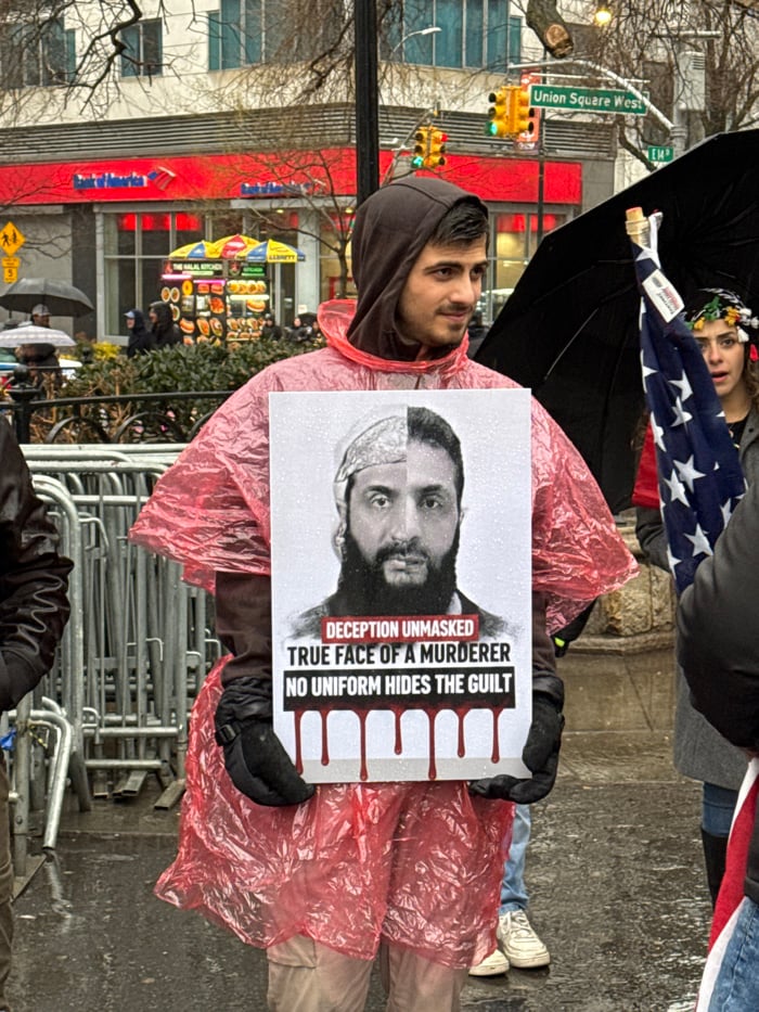 Protesters gather in wet New York square with signs