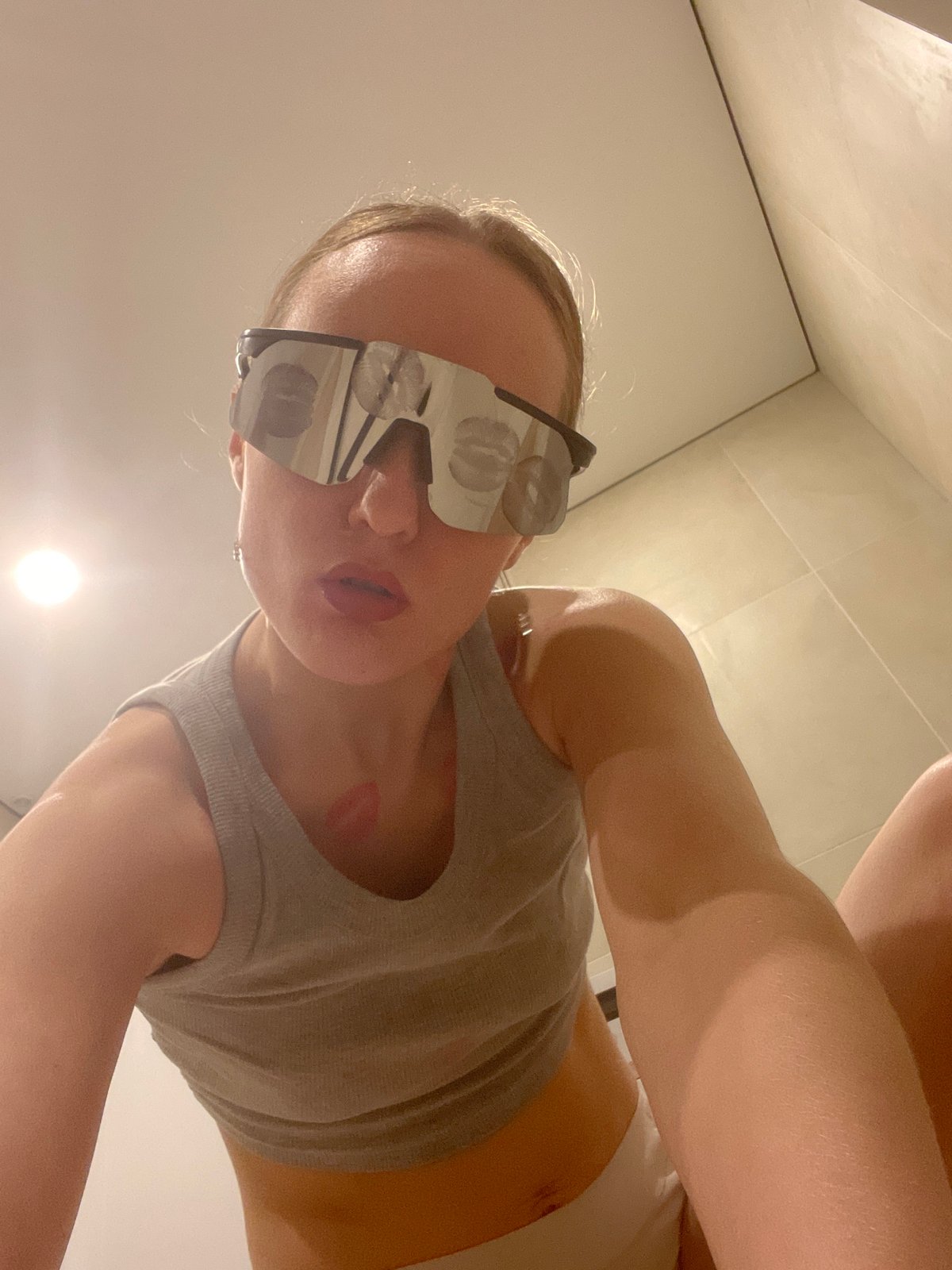 Woman photographed with lipstick marks on face and sunglasses