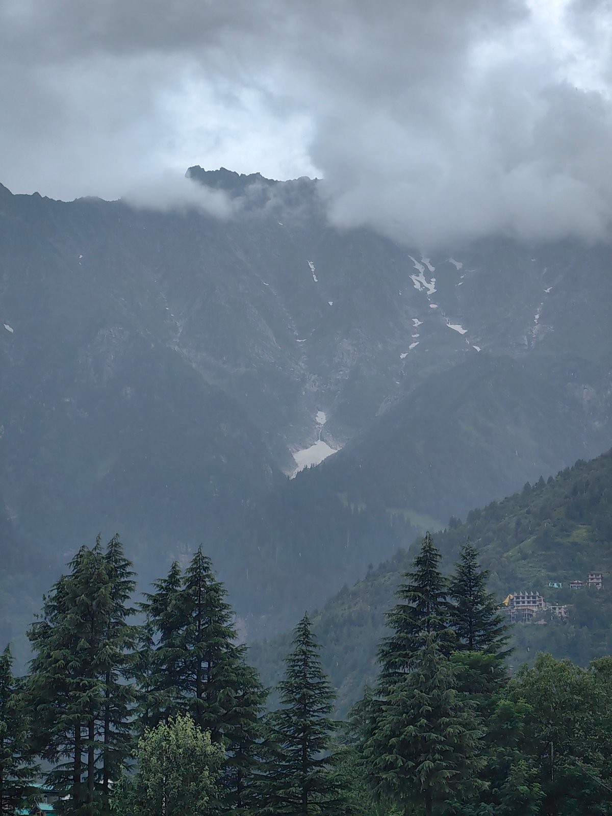 Misty Himachal valley: mountain infrastructure and cloud-covered peaks