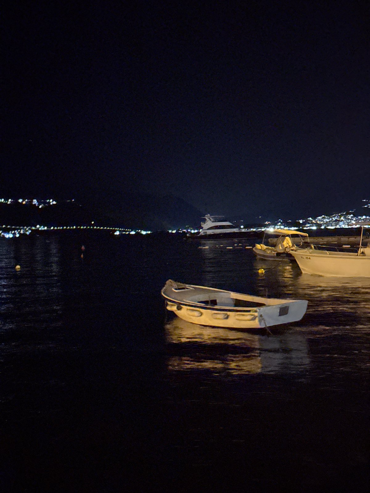 Boats moored in a calm harbor on a quiet night
