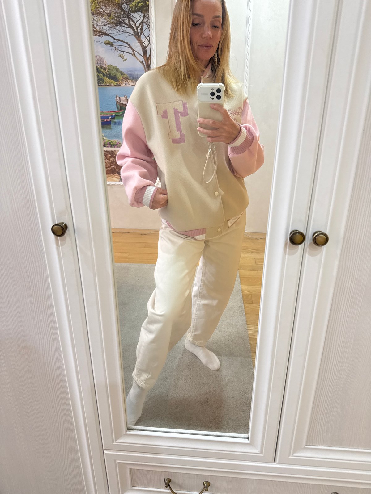 Woman takes mirror selfie in varsity jacket, Vsevolozhsk