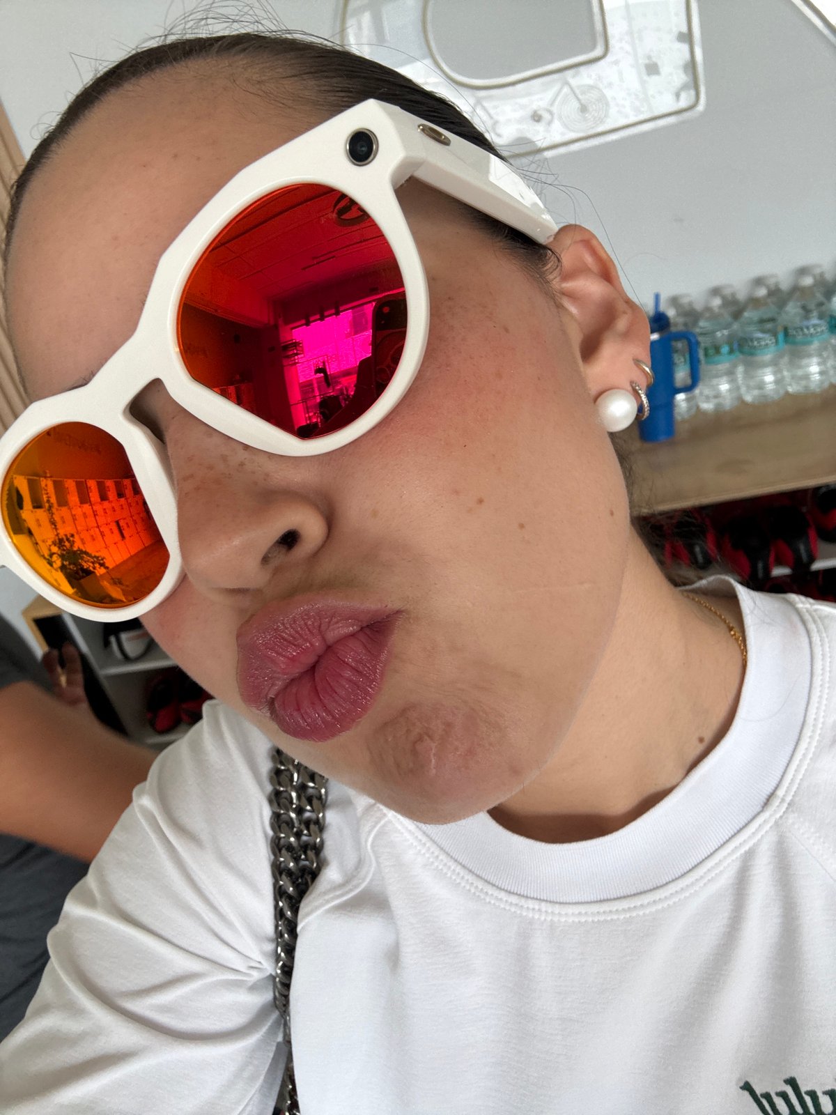 Woman takes selfie in Puebla shop wearing colorful sunglasses