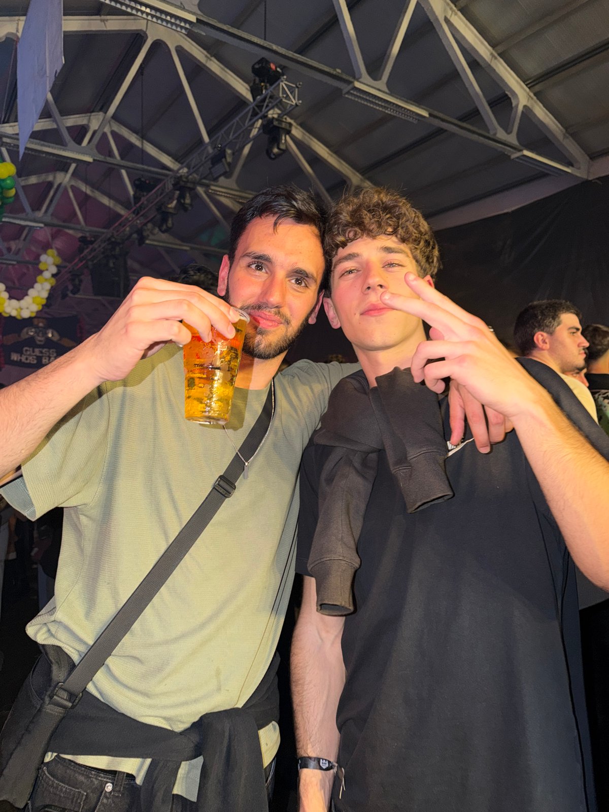 Three men pose with drinks at Bragança indoor event