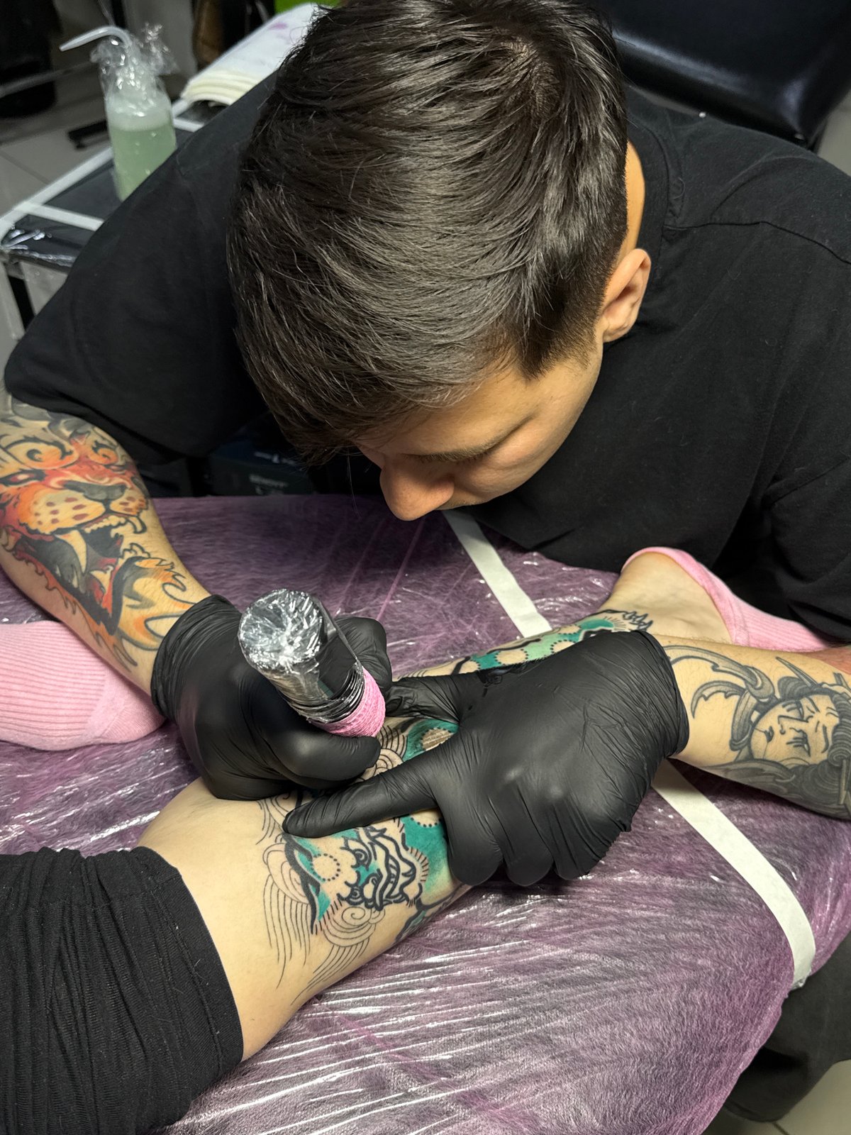 Tattoo artist works on client in Rostov-on-Don