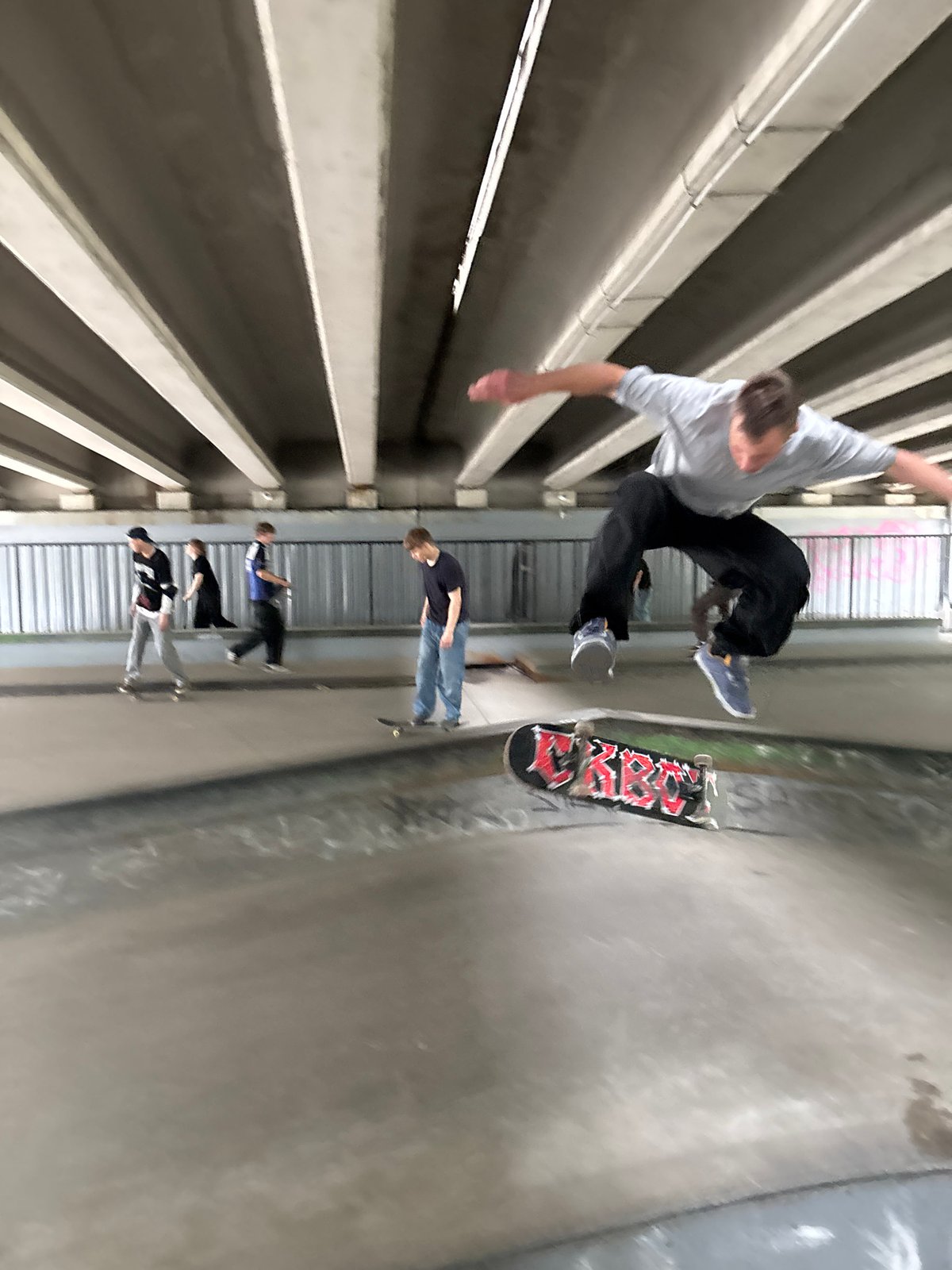 Skaters and a cyclist session an underpass skatepark in St. Petersburg