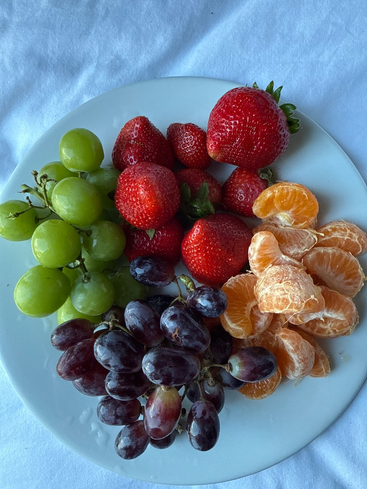 Fresh fruit plate photographed on fabric surface